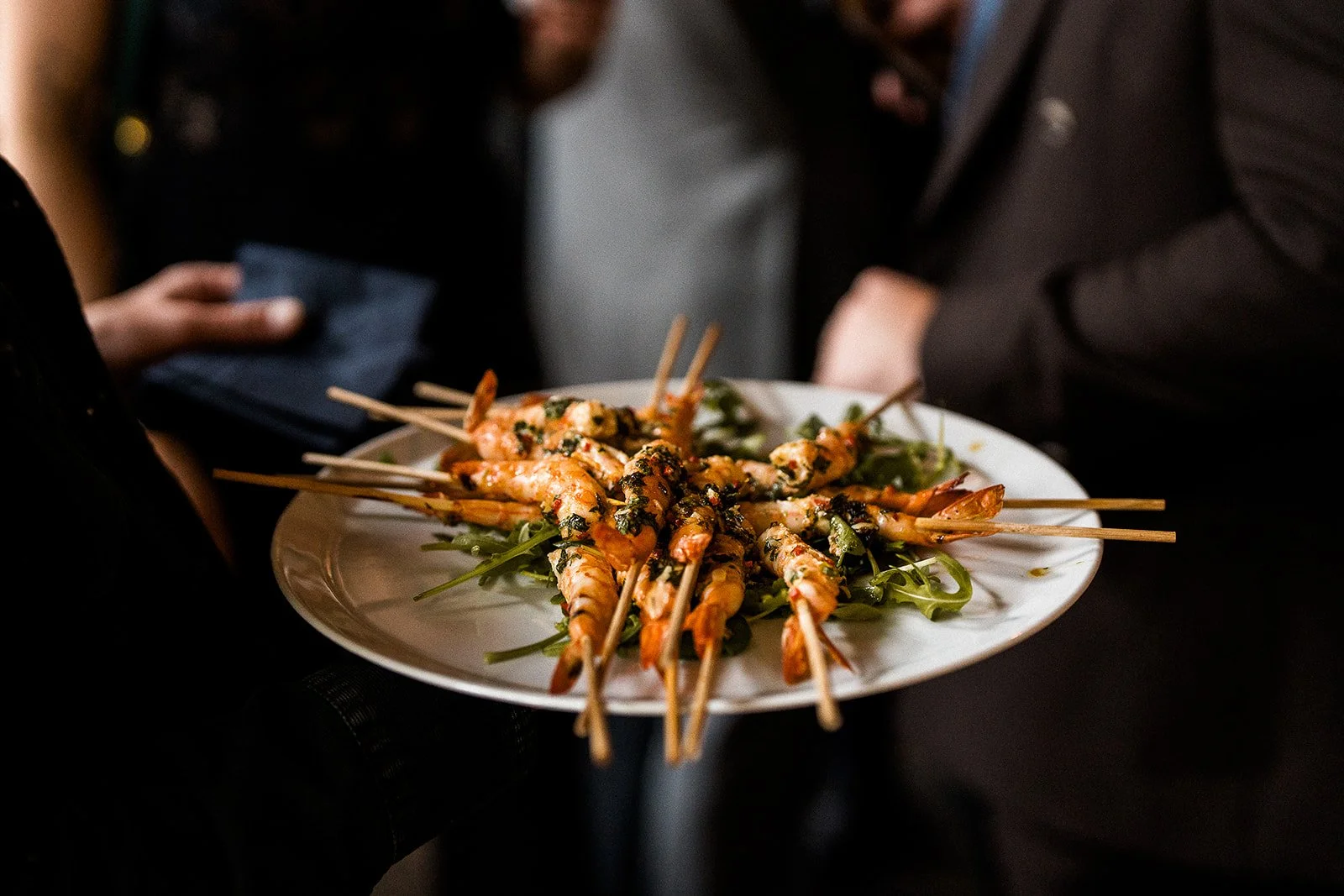 A plate of prawns on skewers at a wedding reception.