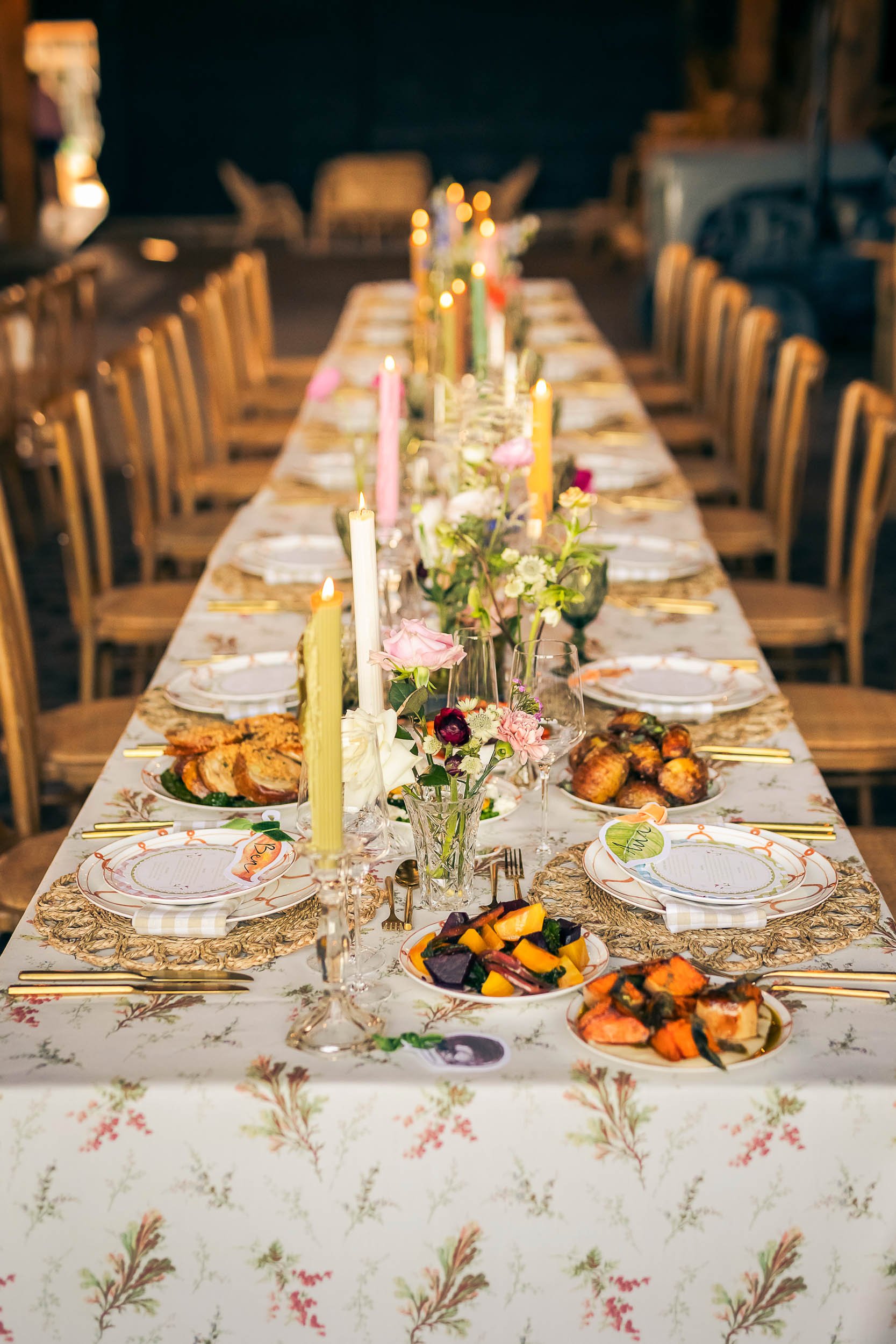 A long shot of a summer wedding table with beautiful stationery and a colourful feast.