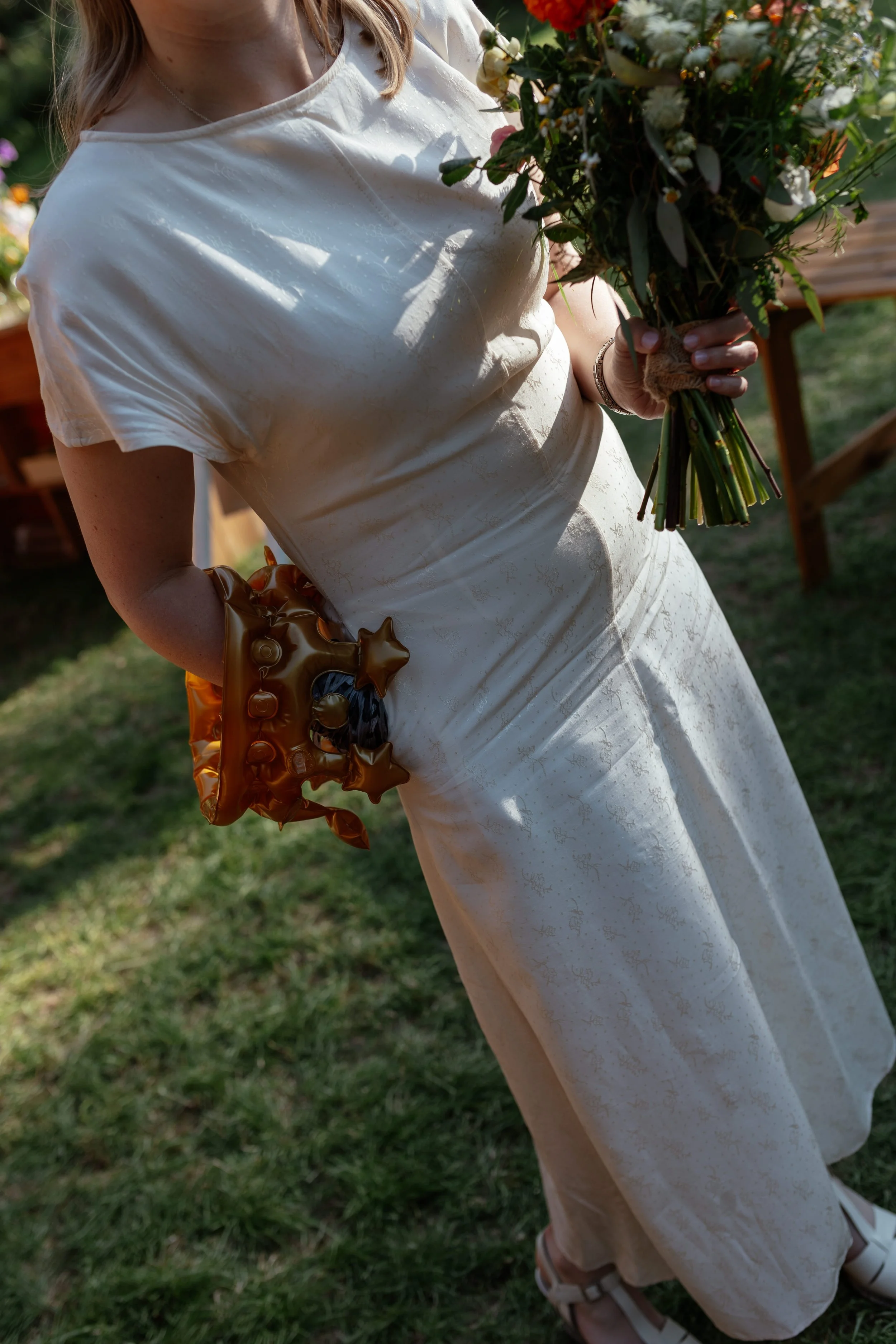 A close up of a bride in a white dress holding her bouquet at Sherwood Glade.