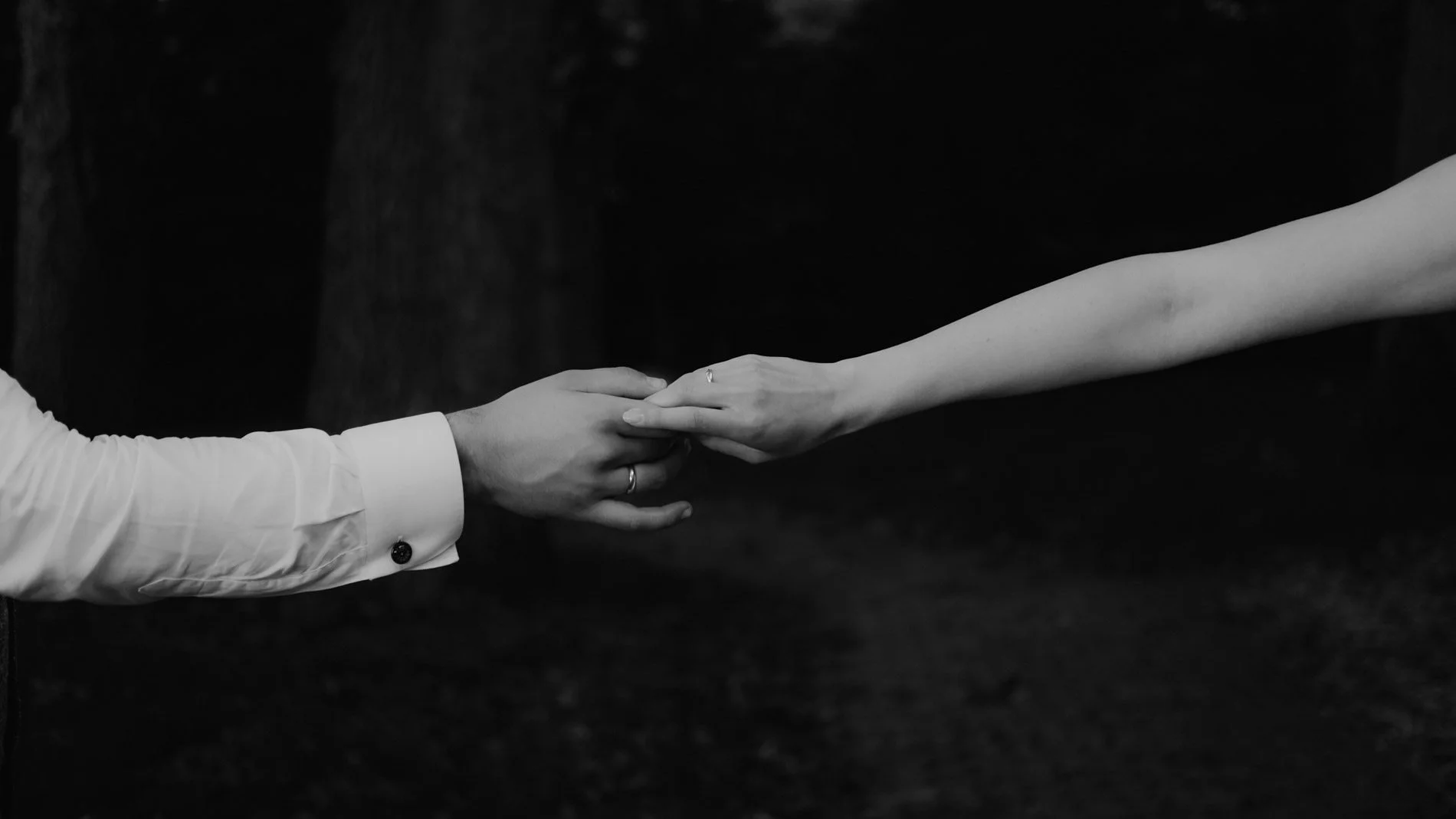 A timeless black and white close-up of newlyweds holding hands, capturing connection and intimacy in a natural, documentary style by Quiet Mornings Wedding Photography in Scotland.