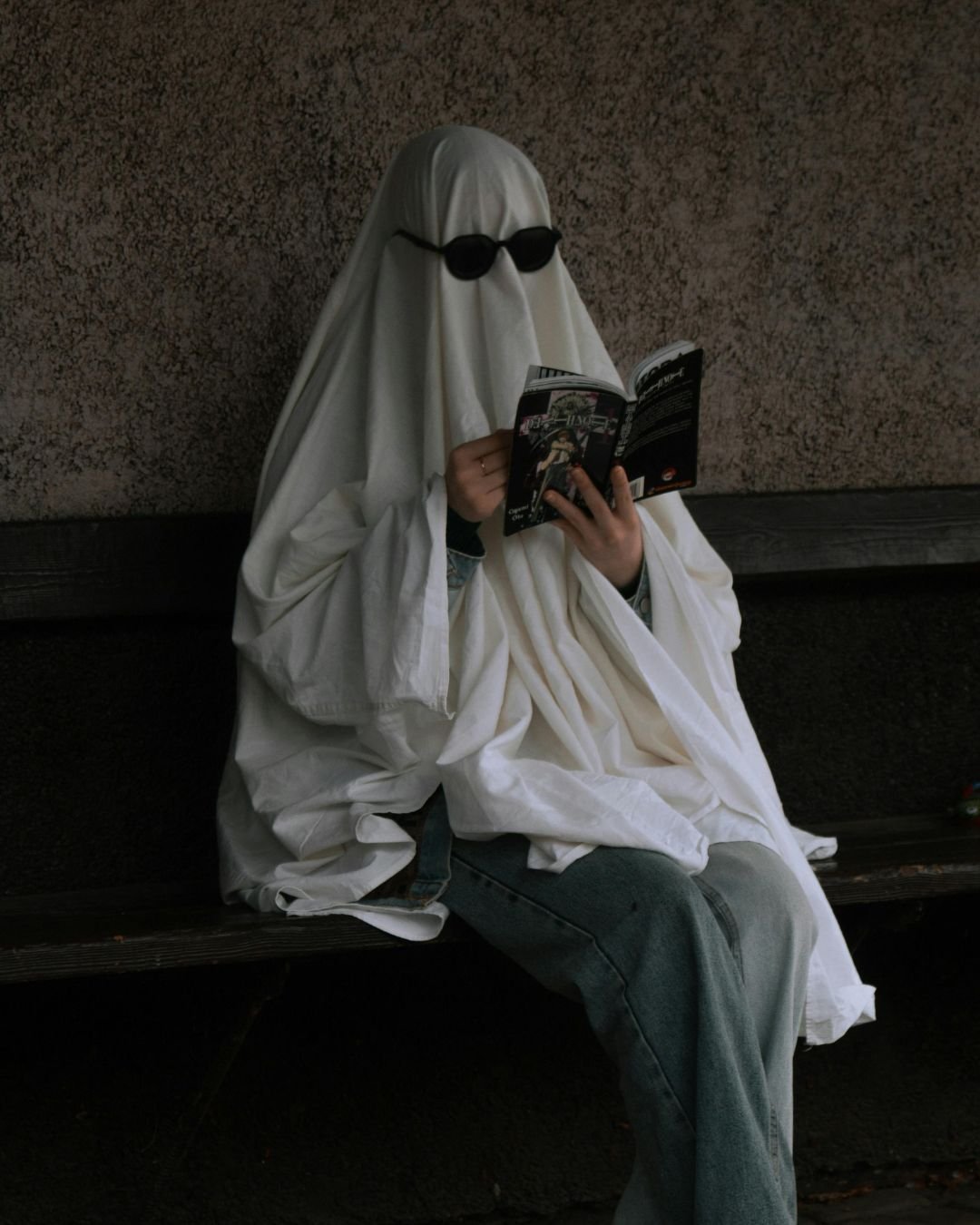 A ghost is reading a book like a normal person.