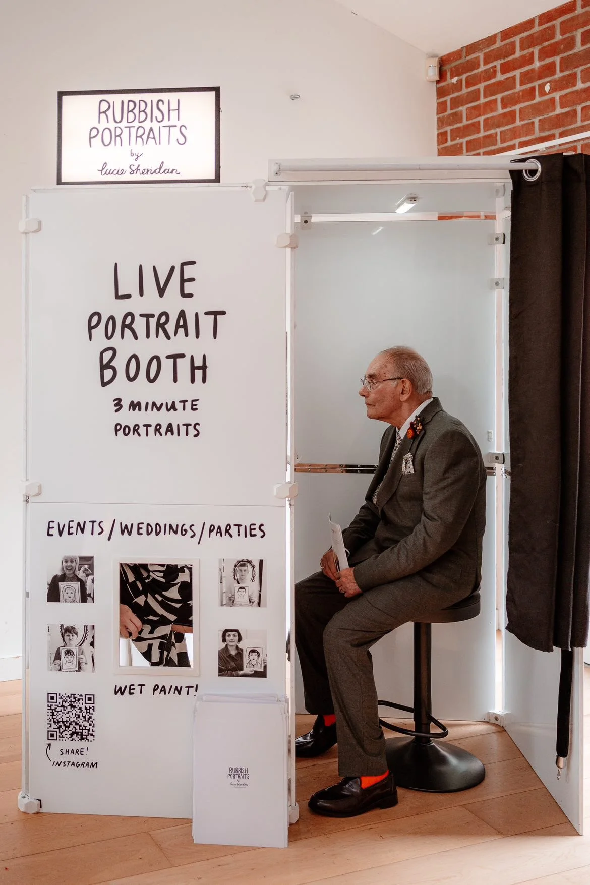 An older gentleman sitting inside the Rubbish Portraits booth at a wedding.