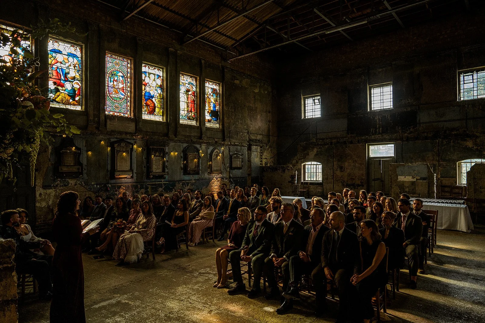 An atmospheric photo of wedding guests inside the Asylum Chapel.