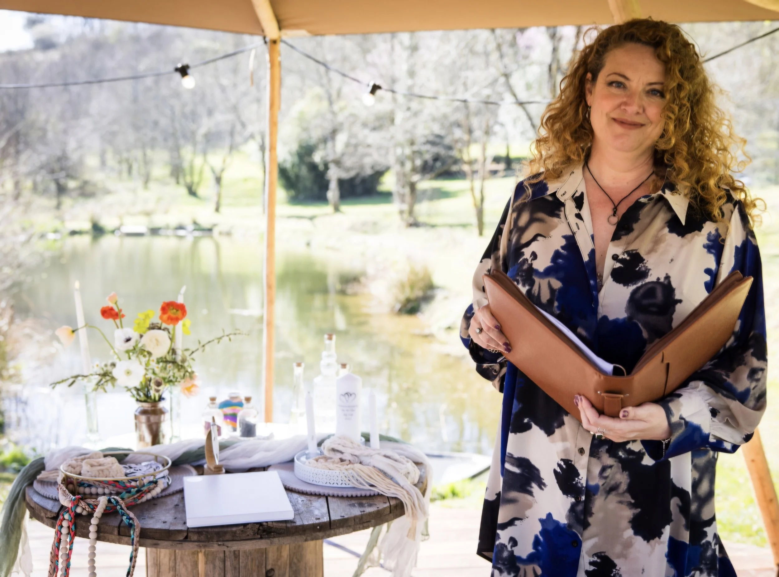 Melly The Celebrant photographed in front of a like prior to conducting a non traditional wedding ceremony. 