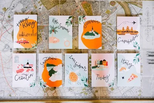 Travel-themed wedding table name cards illustrated by Bee Davies Illustration. Featuring hand-painted destination designs with vibrant colours and modern calligraphy, this bespoke stationery adds a personal, wanderlust-inspired touch - perfect for co