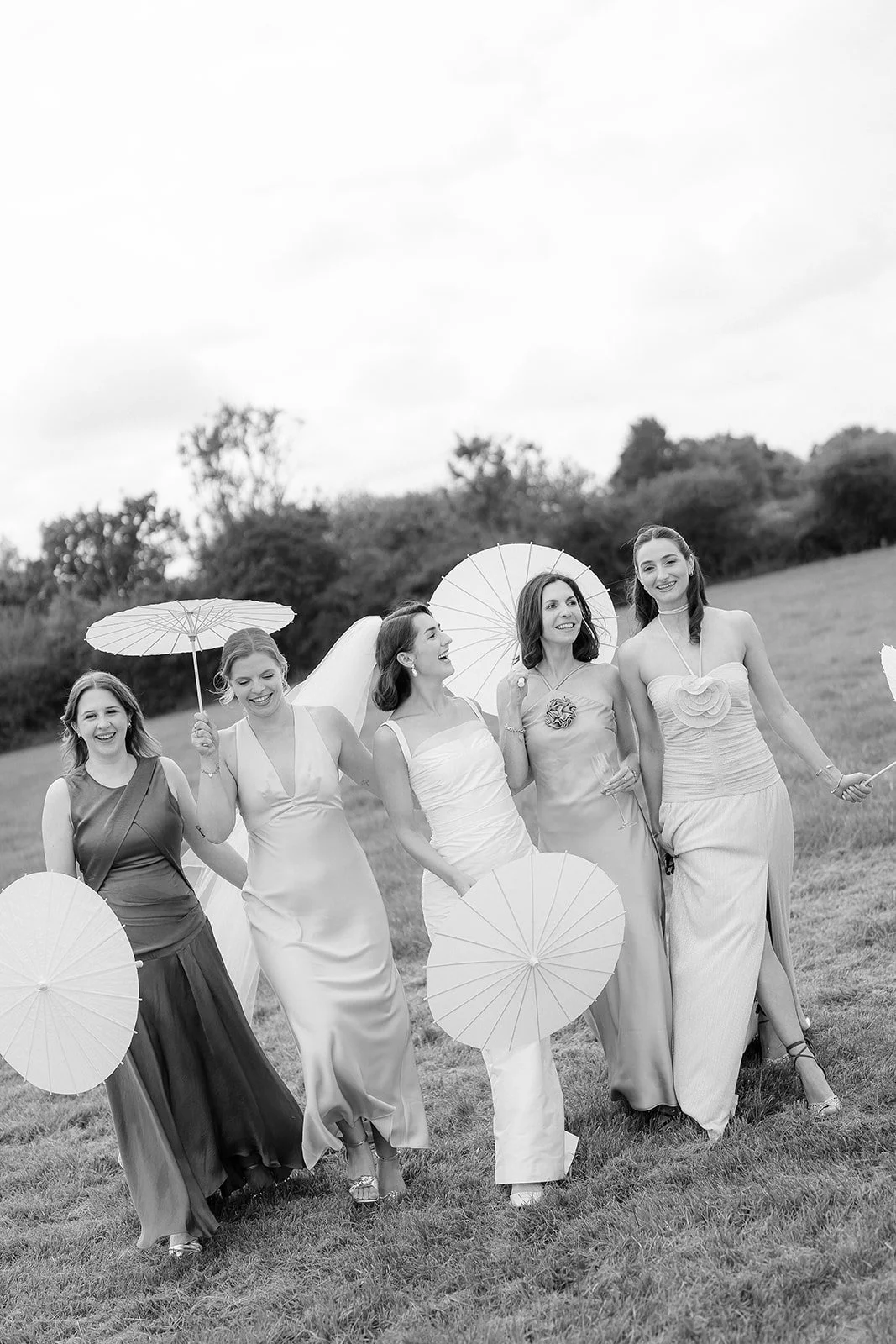 A black and white photo of a bride with her bridesmaids. Bella & George - That Weddings Photo.