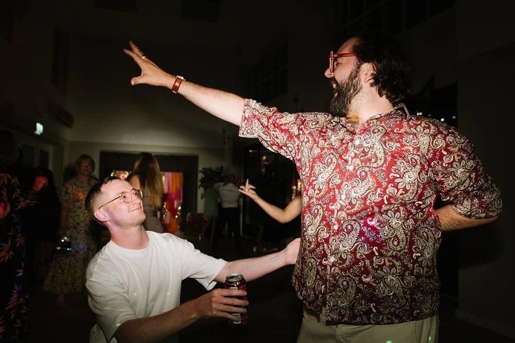 Two wedding guests share a moment on the dance floor, striking playful poses and laughing as the music plays. The fun, carefree energy perfectly captures the atmosphere created by The Best Men wedding DJ.