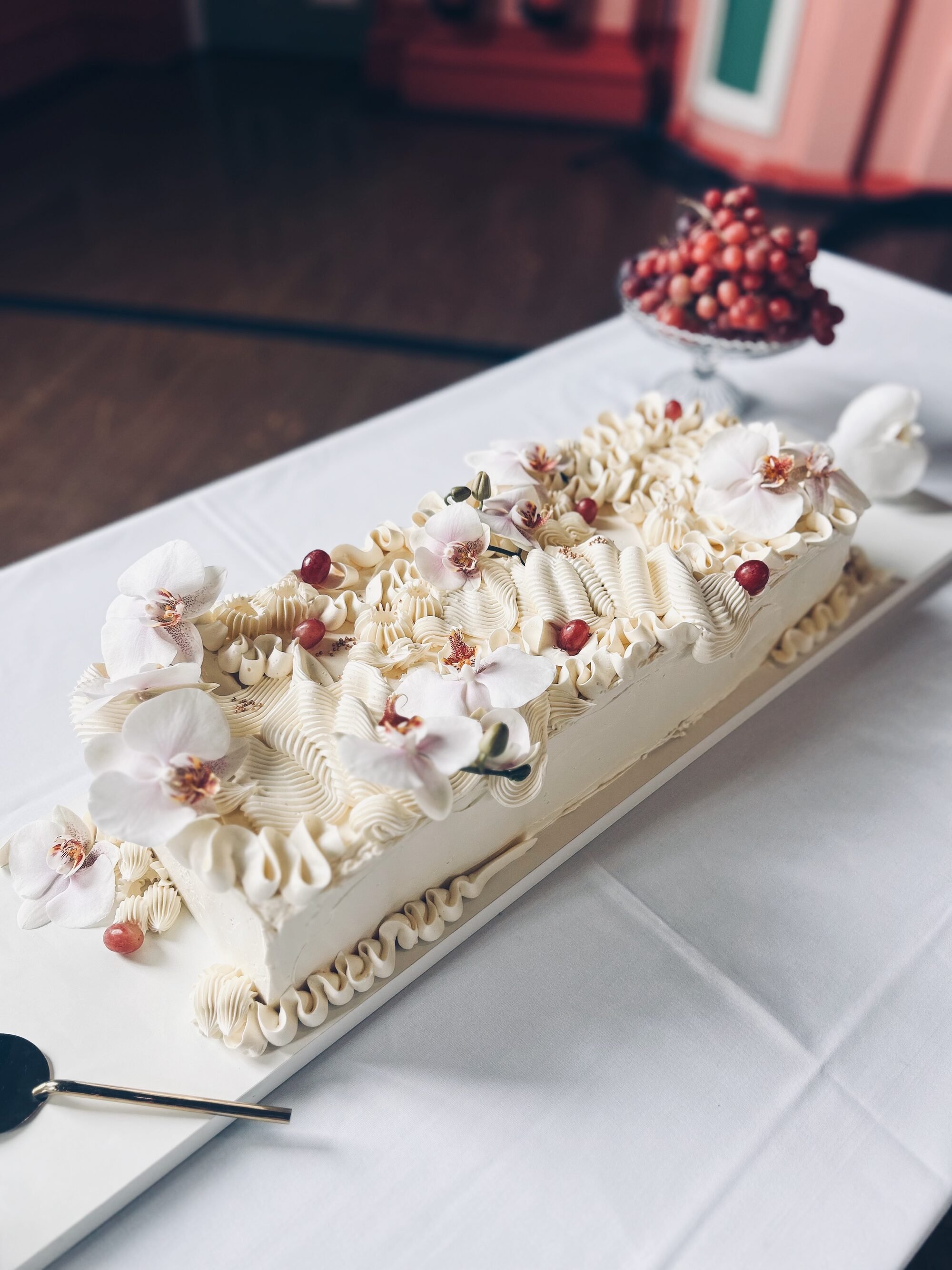 A long, white table cake by Leeds based cake maker, Sarah and Cake. 