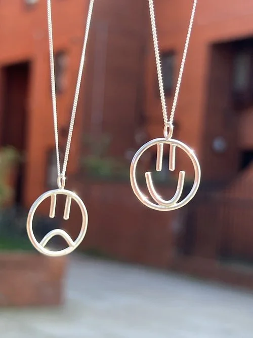 Silver happy and sad face pendant necklaces by Stacey Hill Jewellery, handcrafted in the UK. A contemporary design symbolising emotion and individuality - ideal for unique bridal or everyday style.