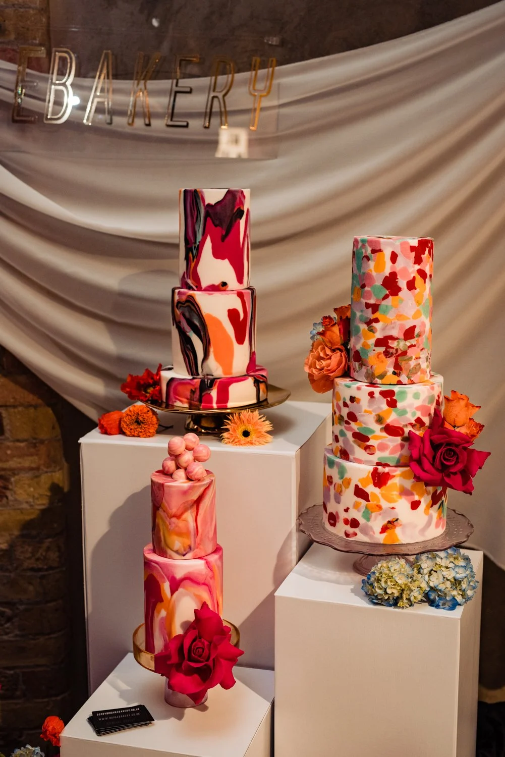 A colourful, marbled wedding cake display at a wedding fair.