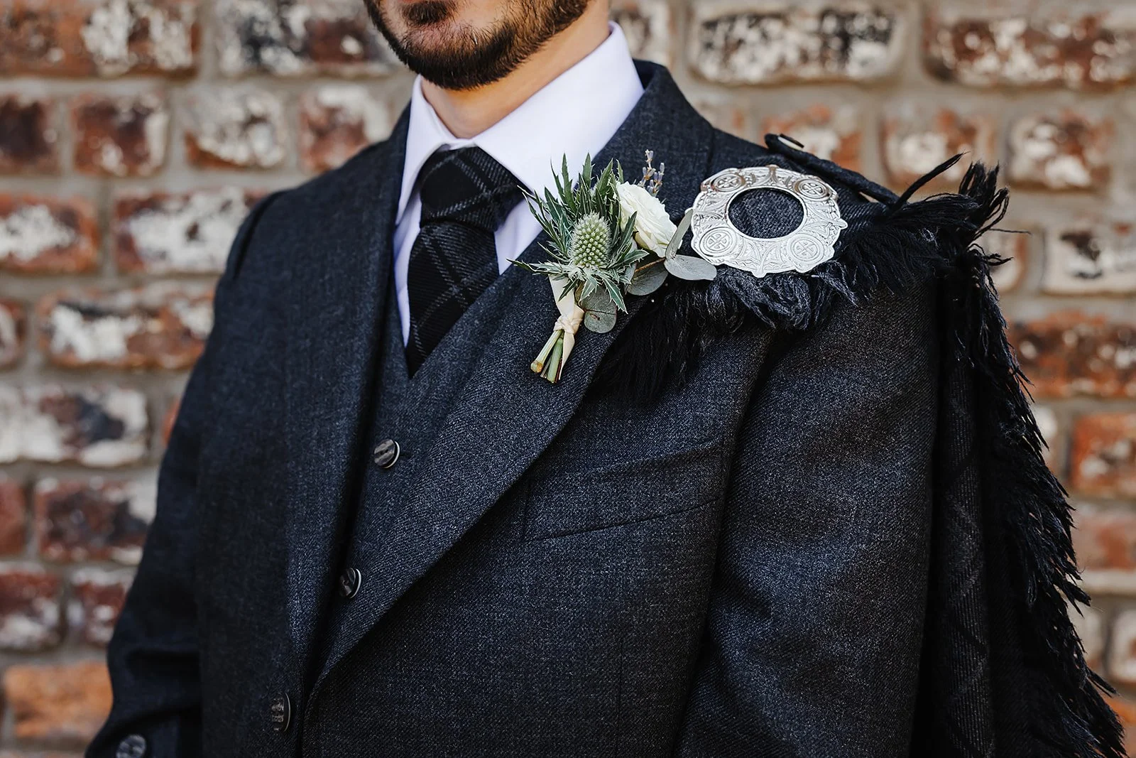 Close up of Oliver the groom, with his Thistle brooch.