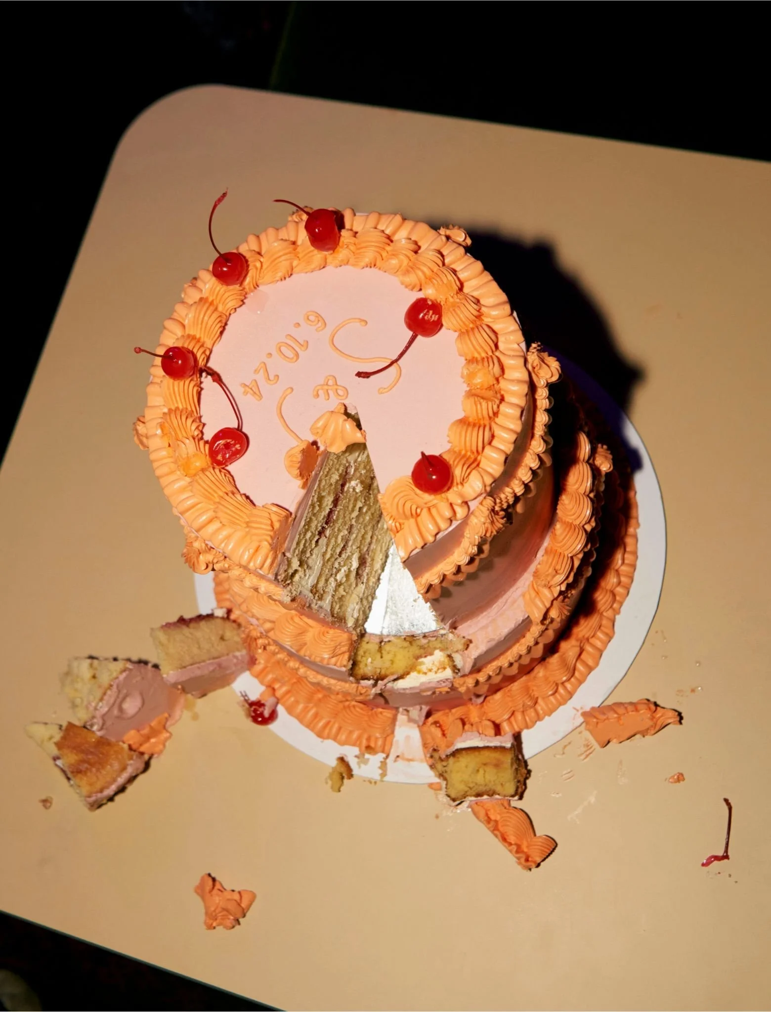 Playful retro wedding cake by The Cake Hun featuring vintage piping, soft peach-pink buttercream and cherry detailing, captured mid-slice. A modern, design-led wedding cake blending nostalgic aesthetics with contemporary styling, perfect for creative