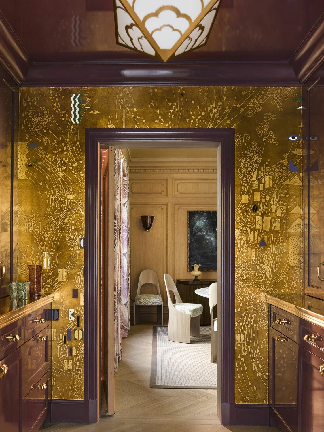 Gold butler's pantry with de Gournay wallpaper inspired by Gustav Klimpt artwork with maroon bar.