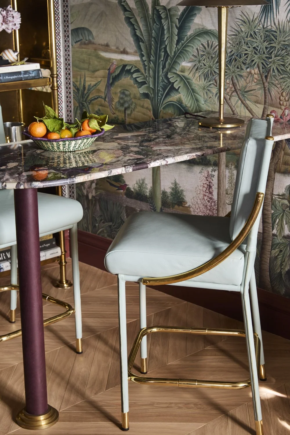Small spaced turned into a secret bar area with exotic foliage wallpaper and two barstools.