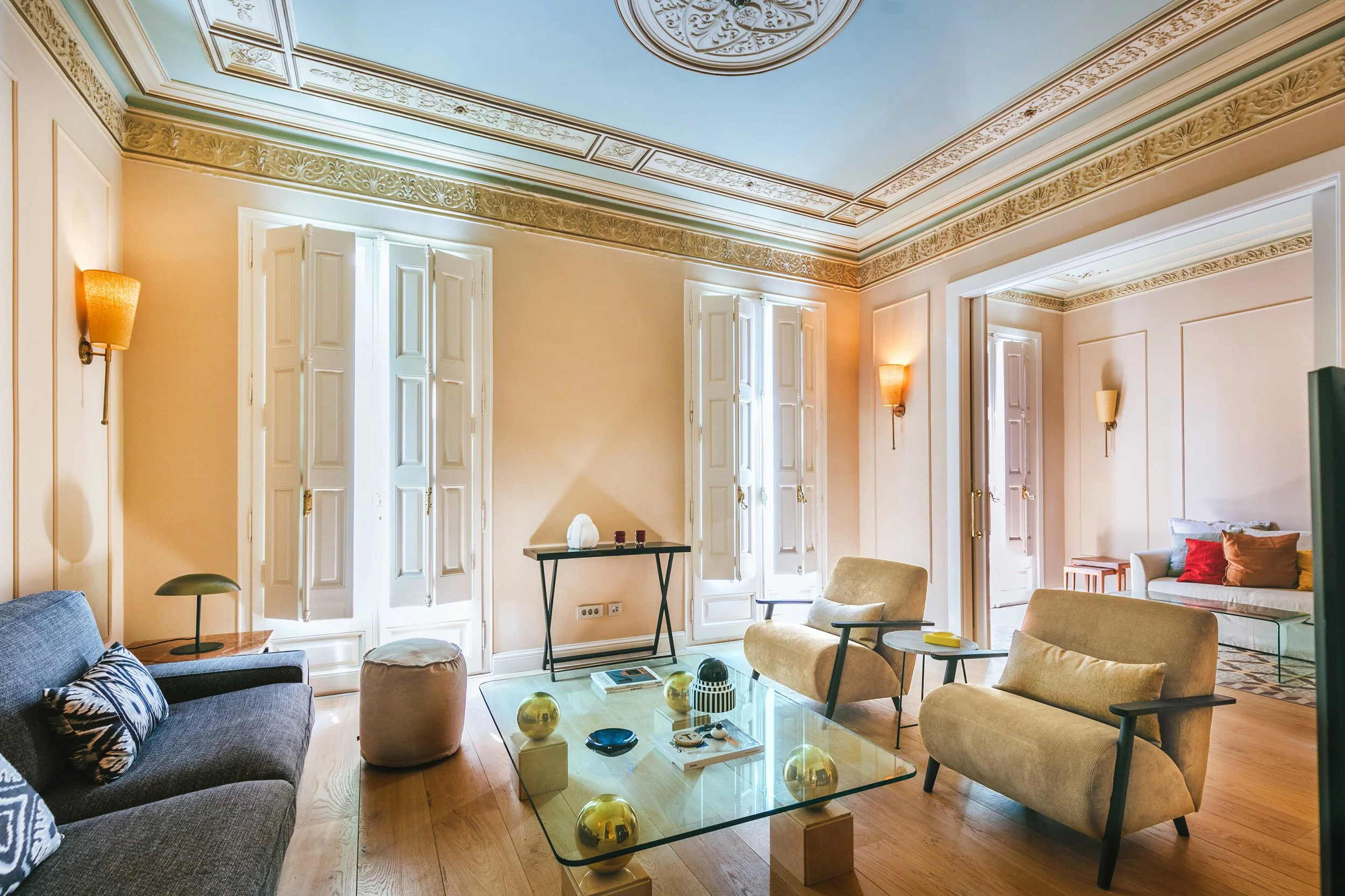 Renovated classic Barcelona apartment interior with ornate ceiling moldings and original shutters