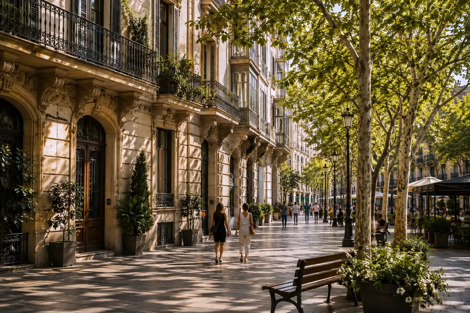 Avenida peatonal arbolada rodeada de elegantes edificios residenciales en el Eixample de Barcelona.