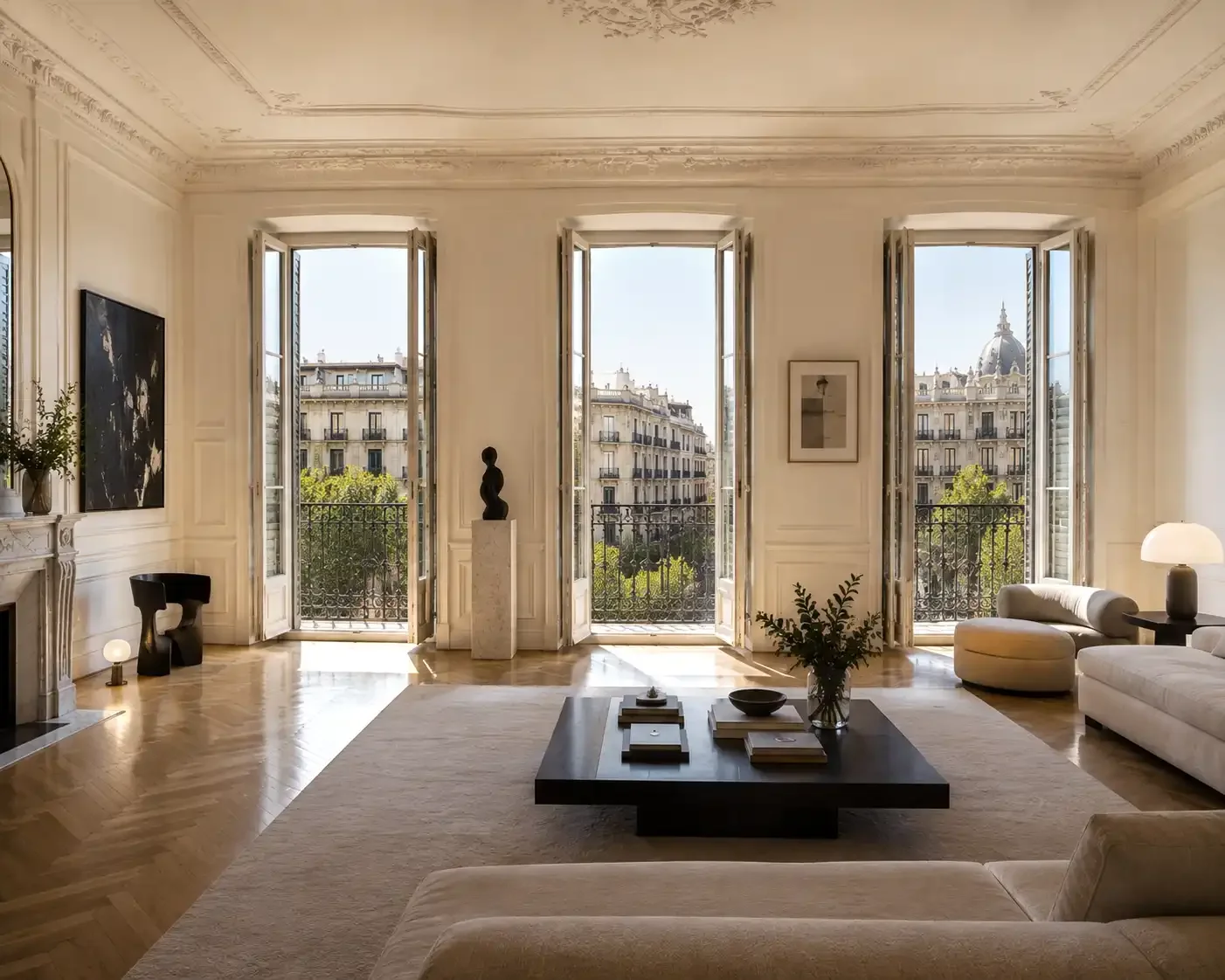 Bright luxury living room inside a renovated Barcelona apartment with three French balconies and classic architectural details.