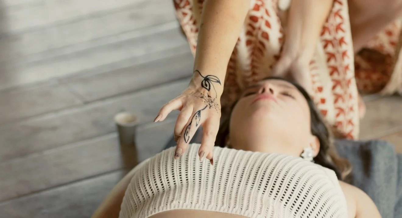 Person receiving a massage from a therapist with a tattooed hand.