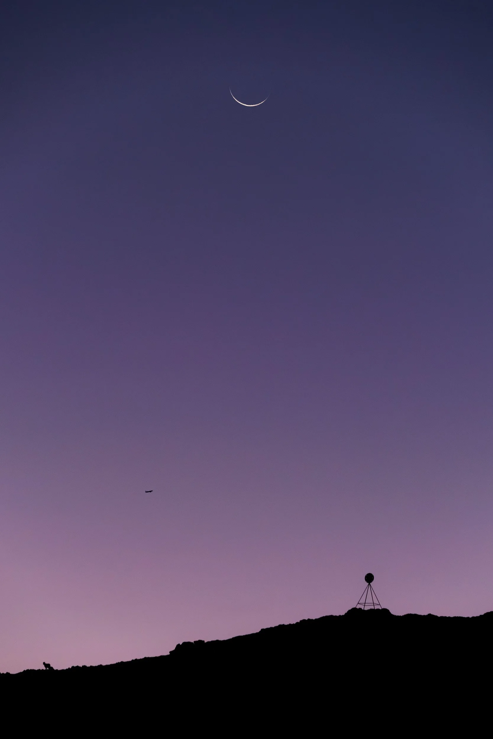 Crescent moon over a trig station.
