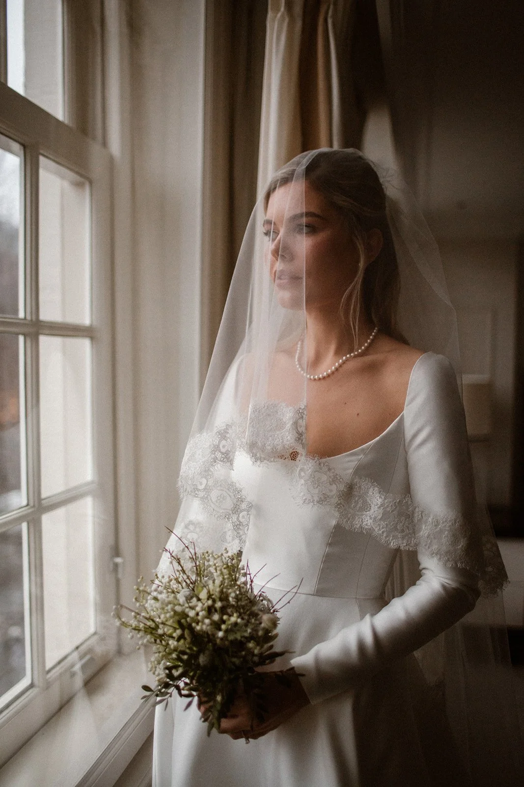 Bride overlooking the canals of Amsterdam during a luxury destination wedding, styled by Italy-based bridal glam artist