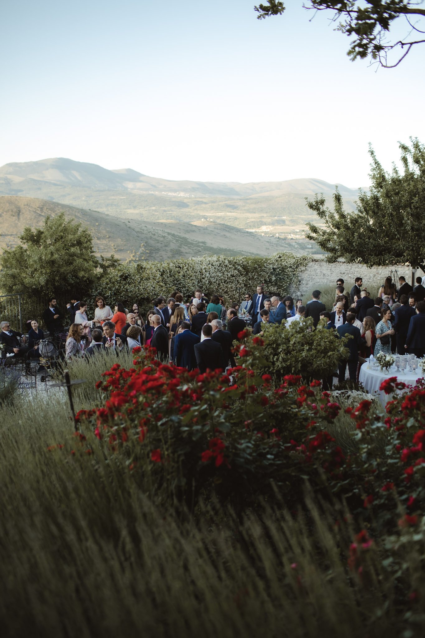 Elegant aperitif setup with floral decor and mountain backdrop during an Italian destination wedding.