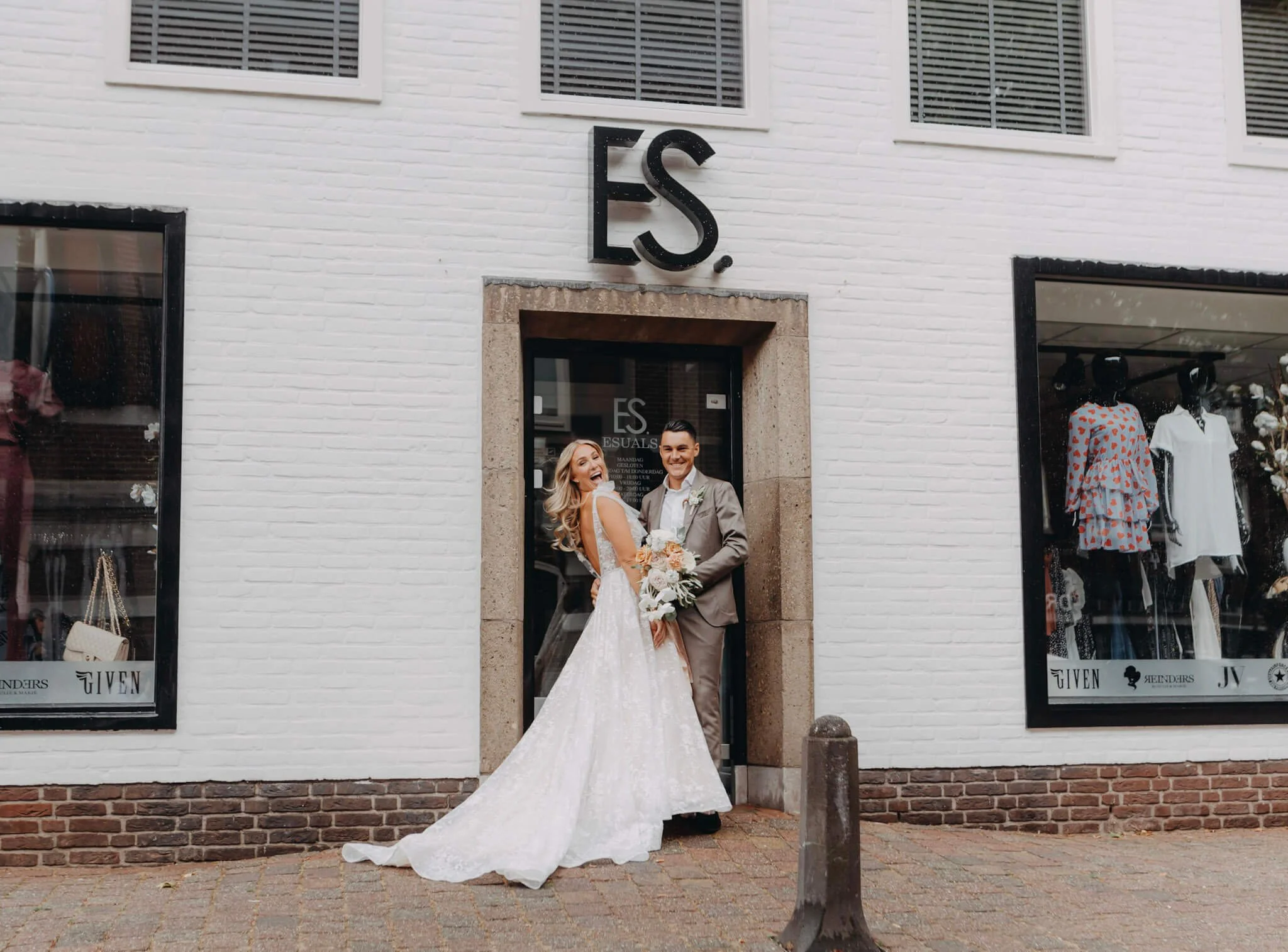 edding couple standing in front of their company signage after their ceremony in the Netherlands.