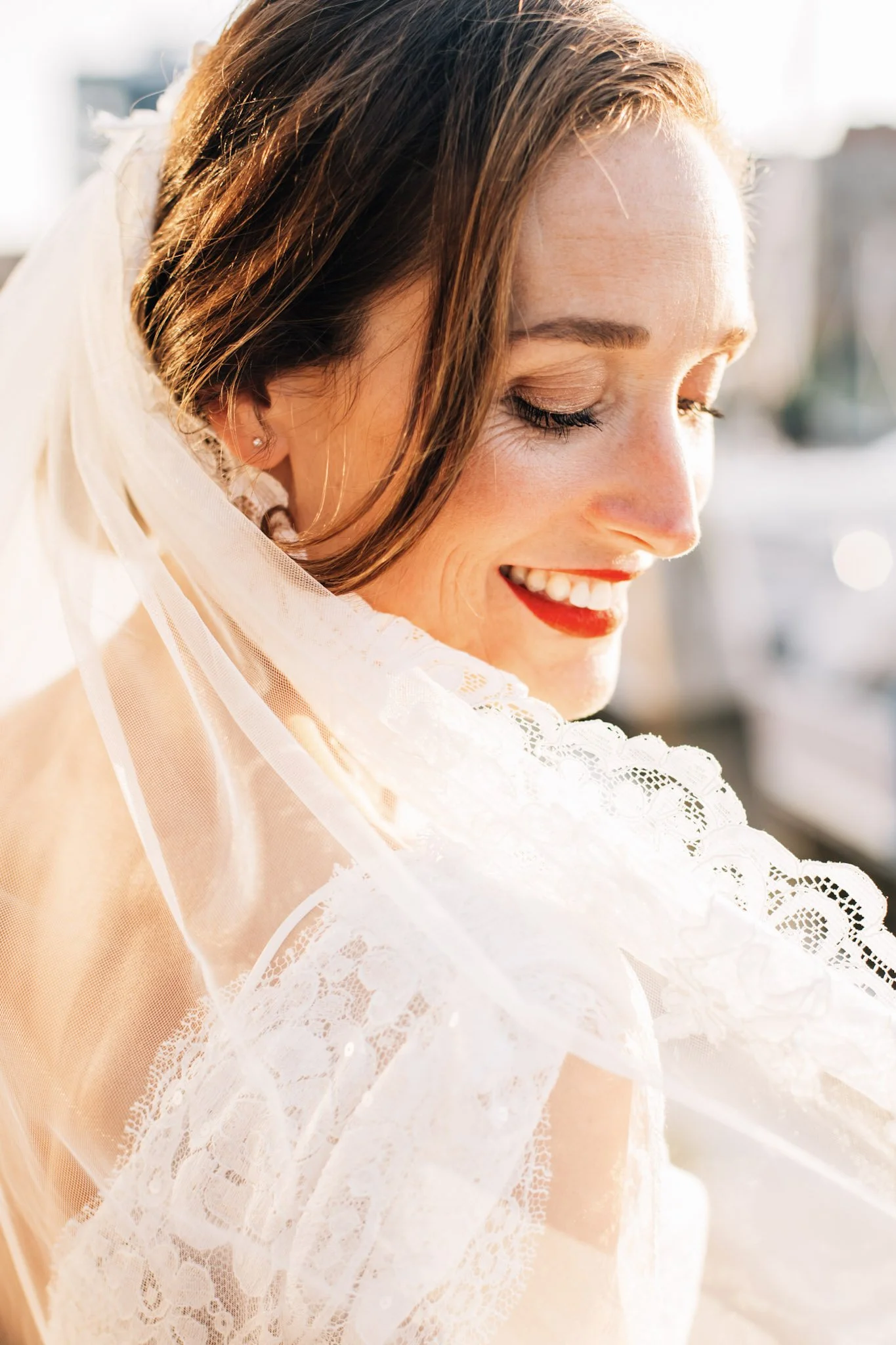 Bride with a red bold lip posing alone at her harbour wedding in The Hague.