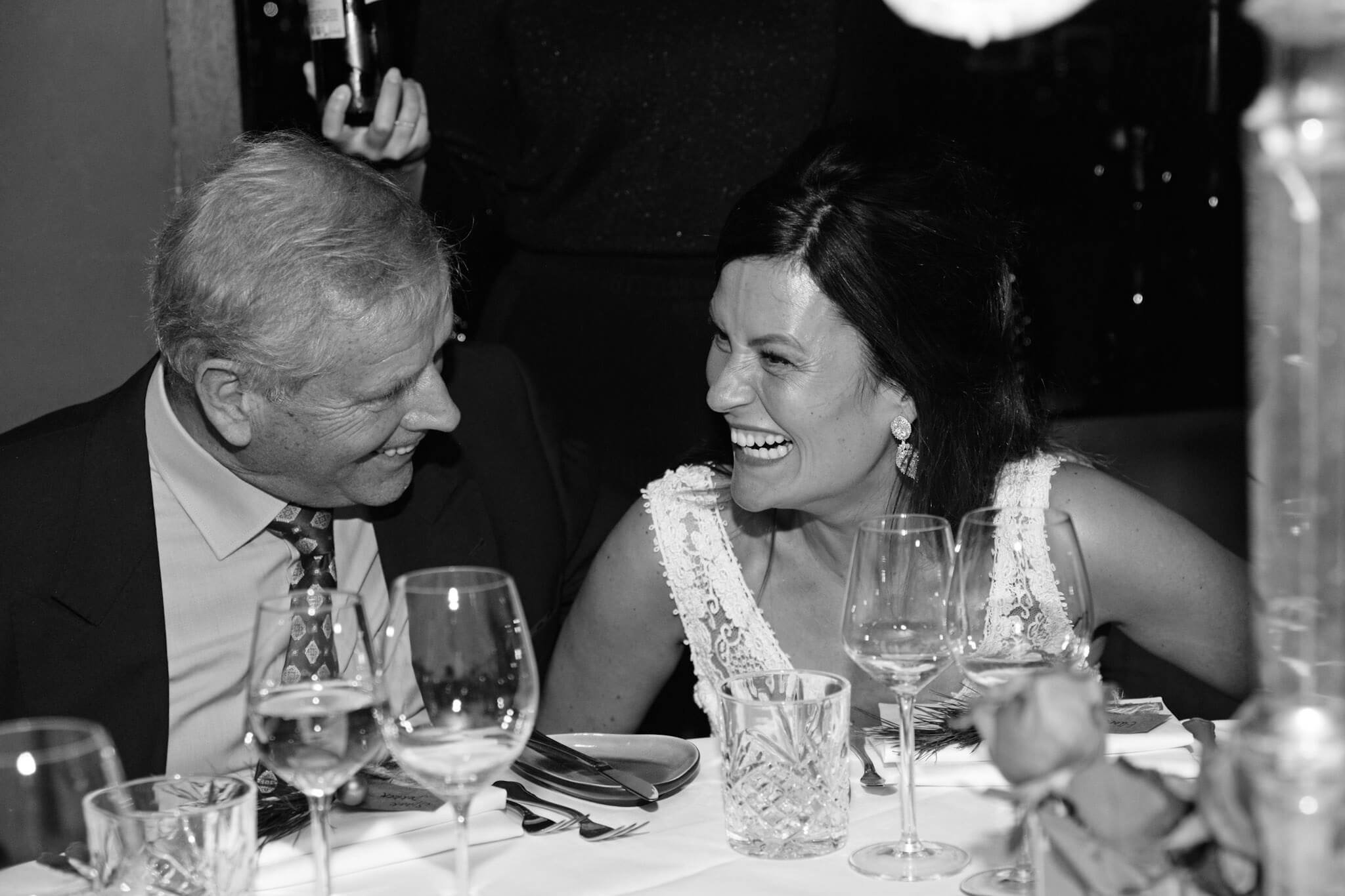 Bride laughing during dinner at a winter wedding in The Hague