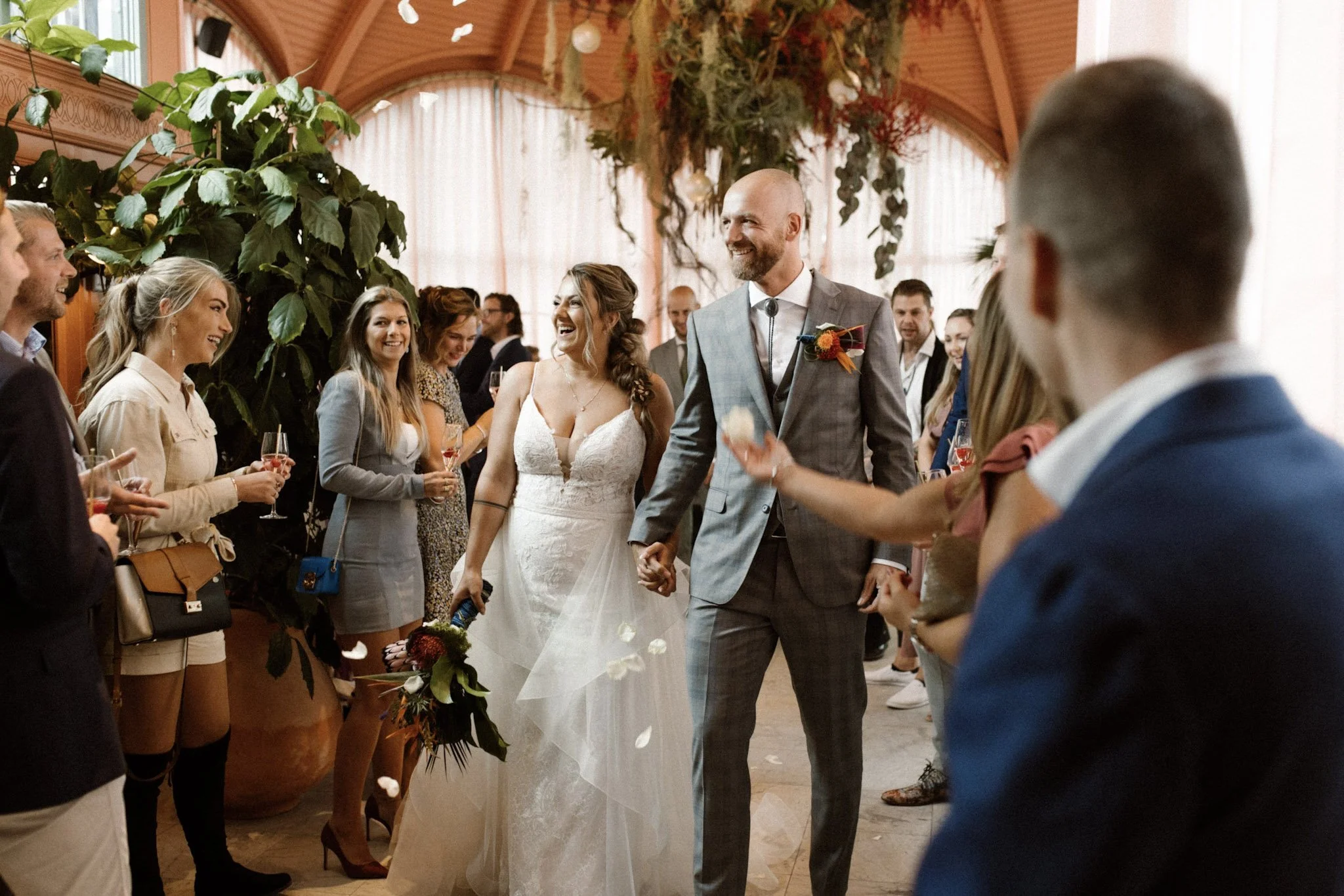 Bride and groom making a happy entrance during their bohemian wedding at Zalmhuis.