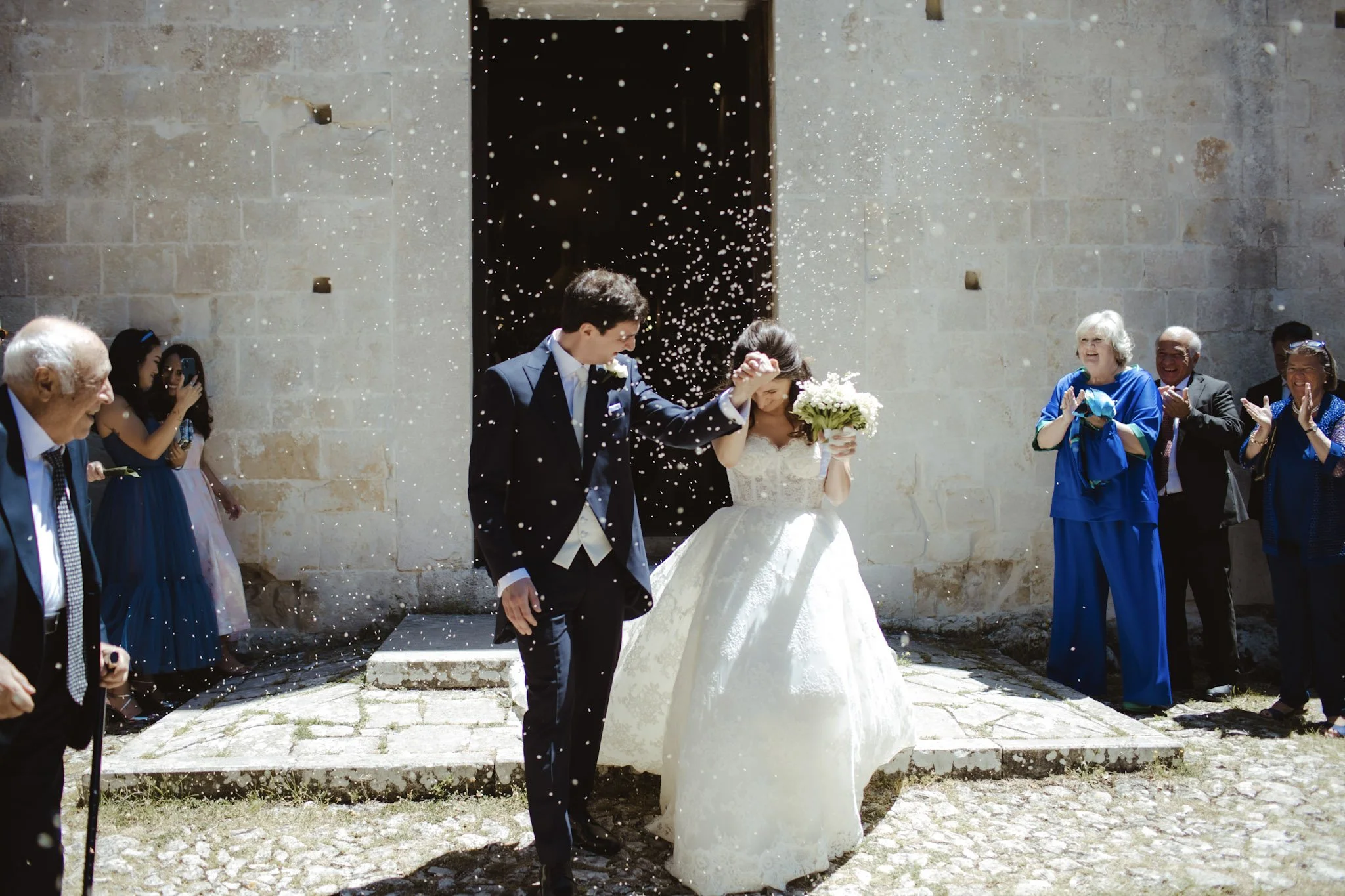 Bride stepping out of the church in her Zuhair Murad gown after a luxury wedding ceremony in Italy.