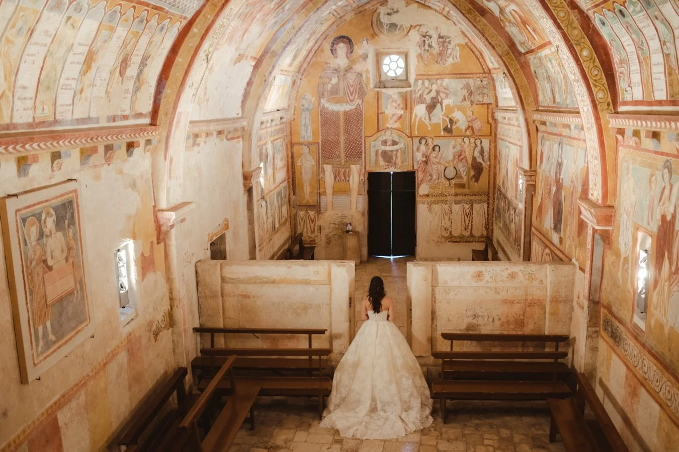 Bride walking down the aisle in an elegant Italian church during a luxury wedding ceremony.