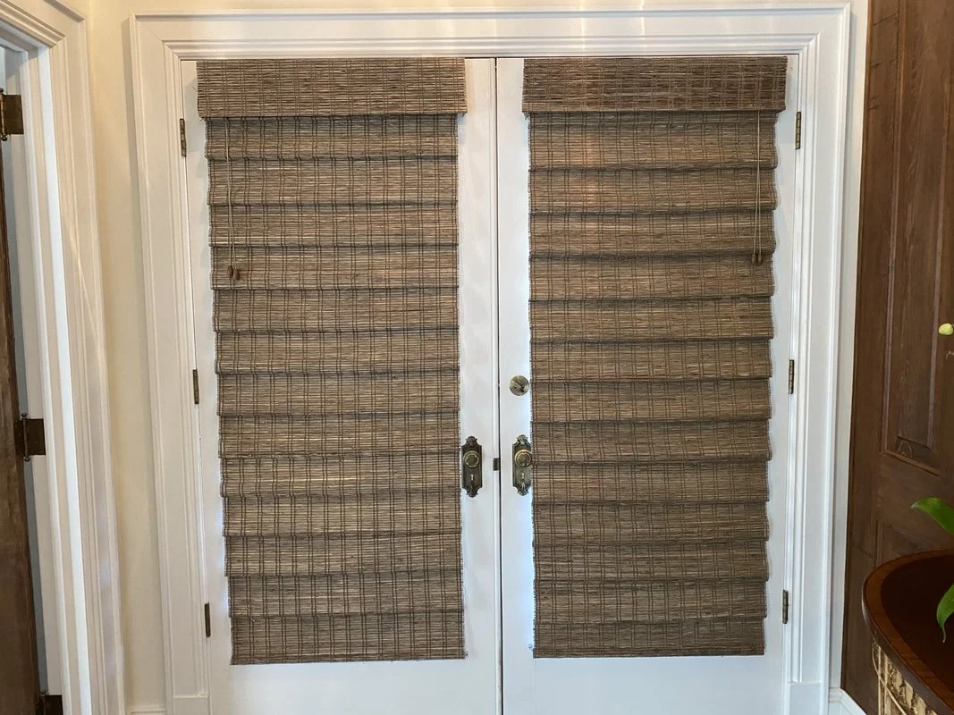 Double door with brown woven shades covering both panels.