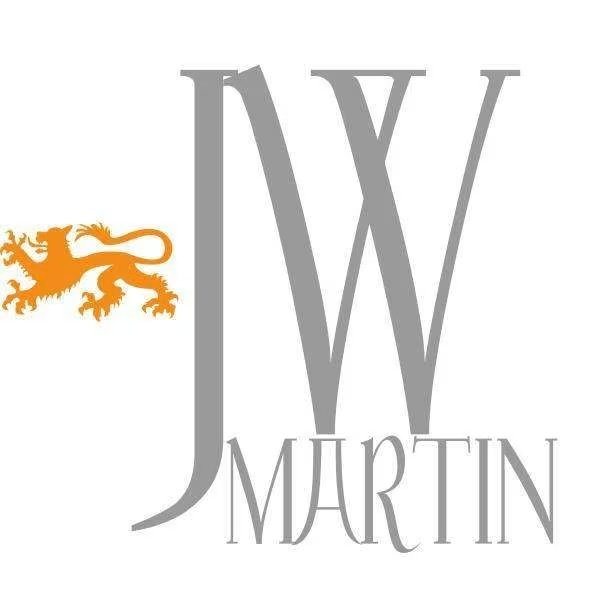 Logo with large gray initials 'JW' and the name 'Martin' beneath, featuring an orange lion emblem on the left. Shan Media Company Social Media MGMT