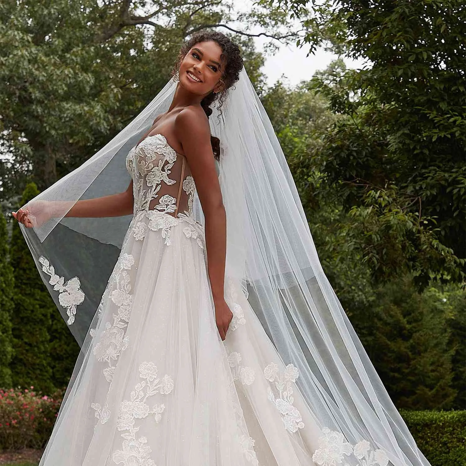 Morilee by Madeline Gardner ballgown wedding dress at Dress Me Up Lincolnshire. This sparkly bridal gown features a crystal-beaded bodice, plunging V-neckline, and a voluminous sequined tulle skirt with a cathedral-length train.