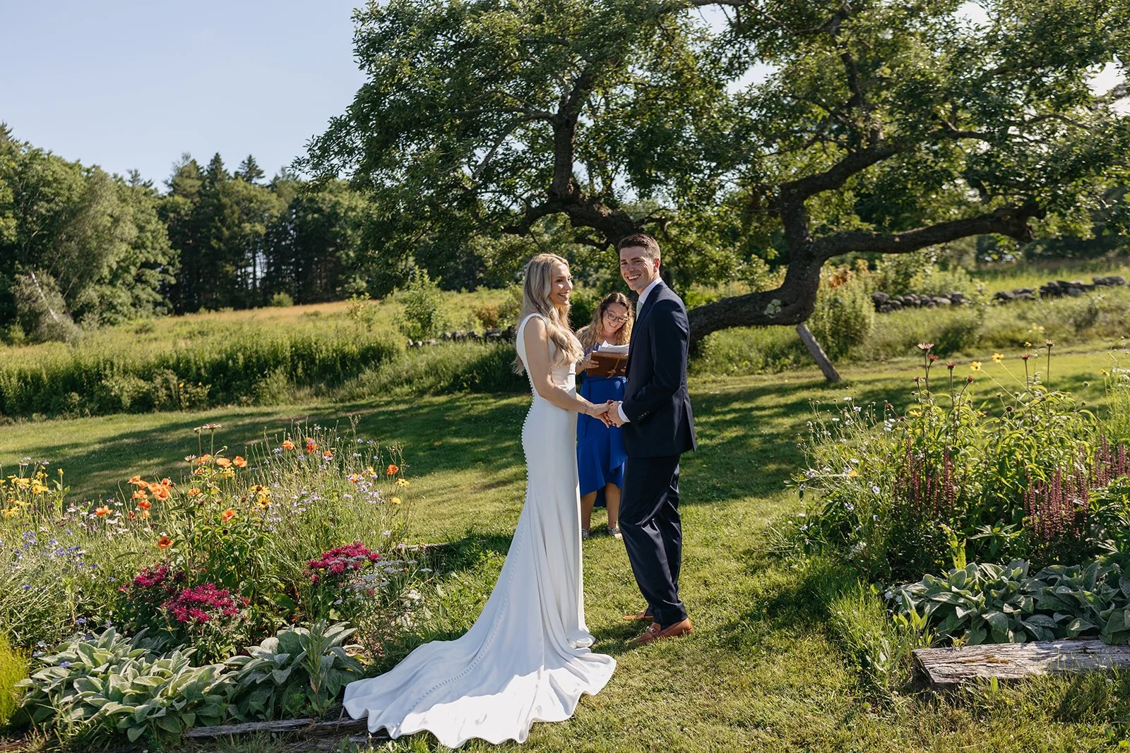 wedding photography of a ceremony in front of an apple tree at tops'l farm wedding venue