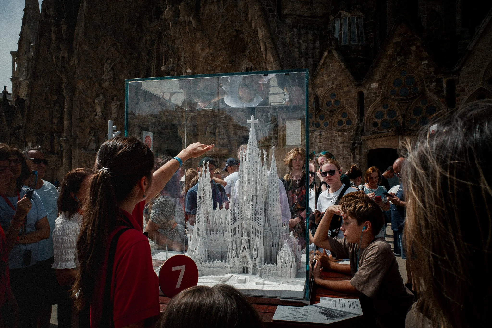 Un grupo de visitantes observa una maqueta iluminada de la Sagrada Familia en el interior del templo.
