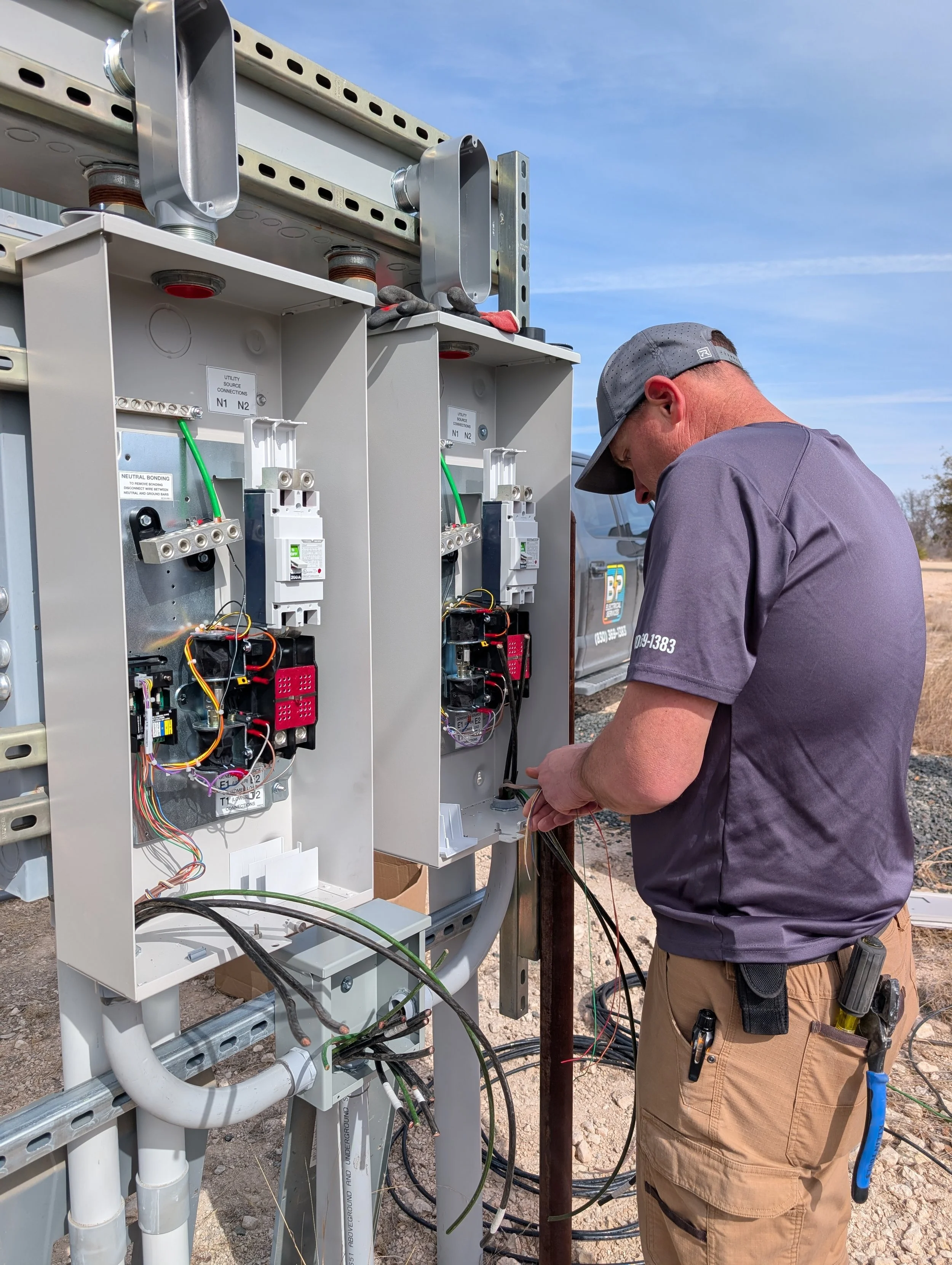 Jason Payne, owner of BP Electrical Services, works with a breaker box on a job site.