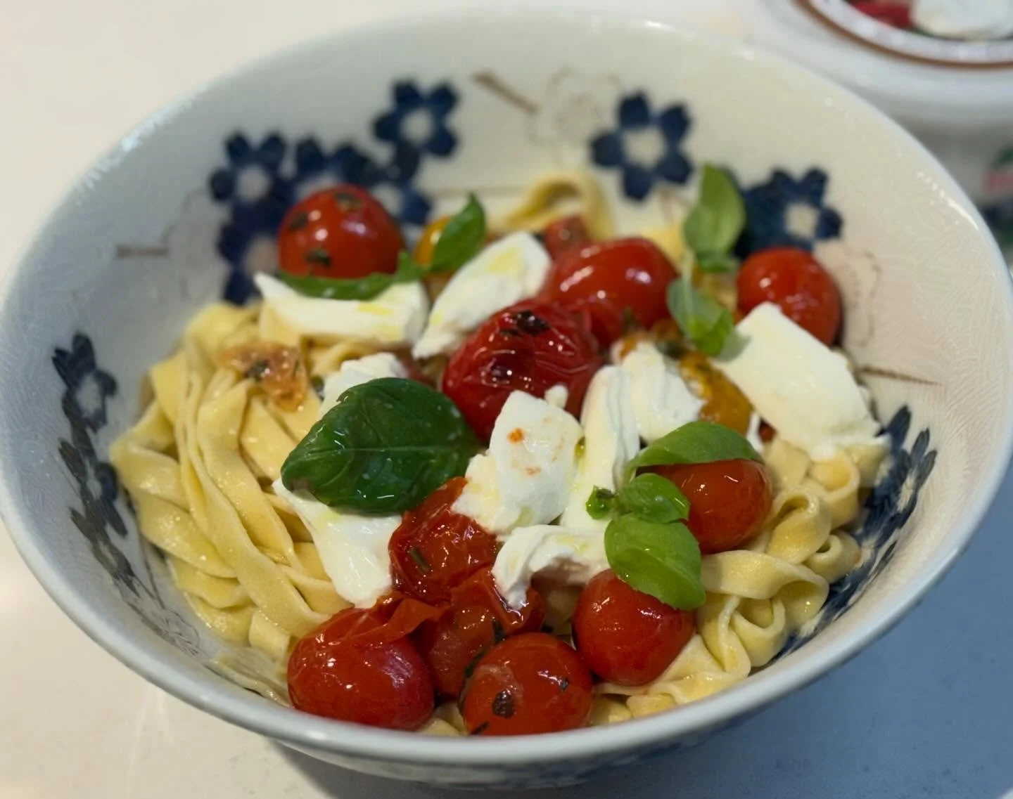 Amazing fresh egg fettuccine! The sauce is so simple: cherry tomatoes blistered in garlicky oil with some red pepper flakes, anchovy and parsley, and served with burrata and fresh basil. Yum!