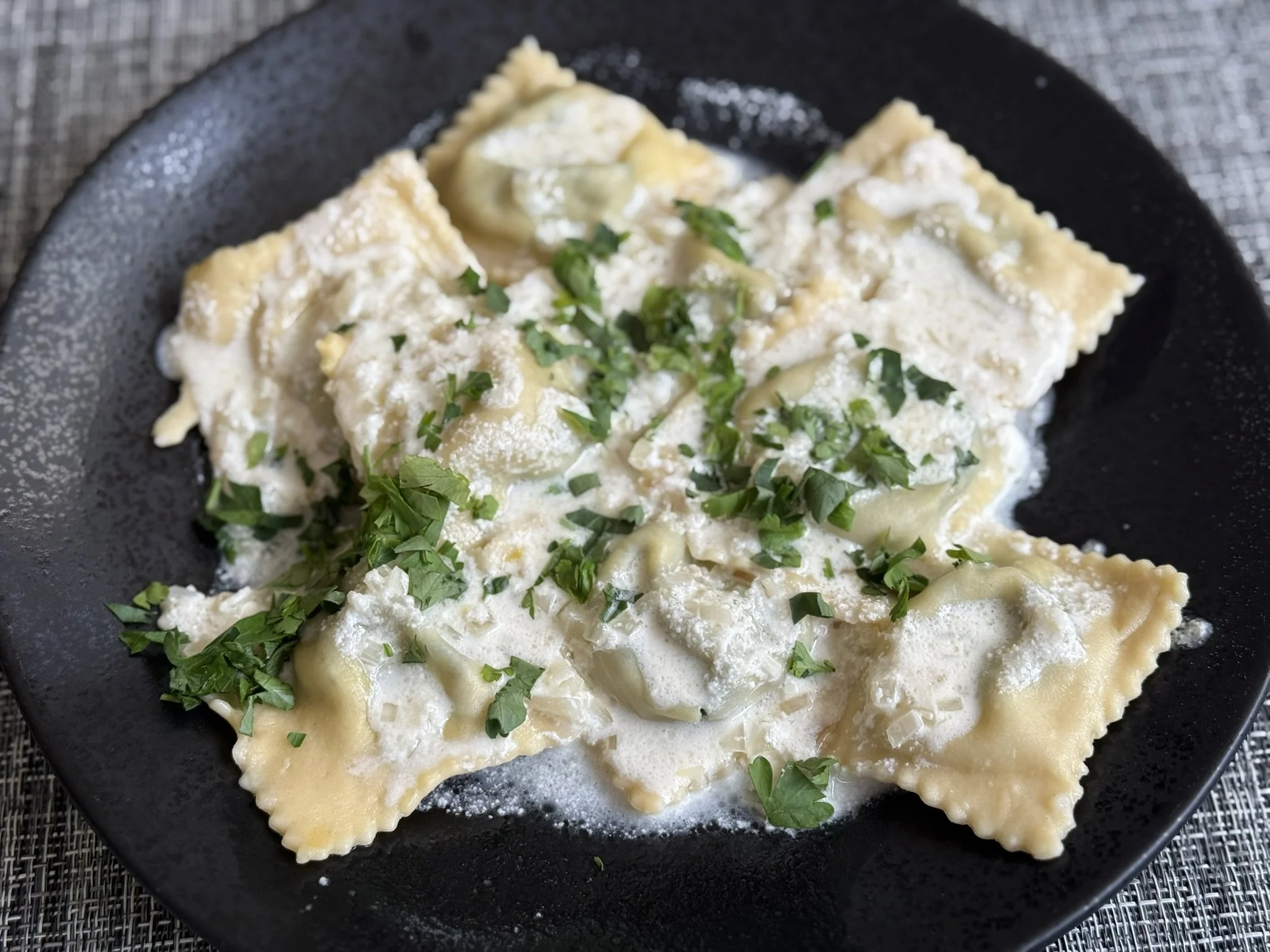 Fresh ravioli with spinach-ricotta filling and cream sauce