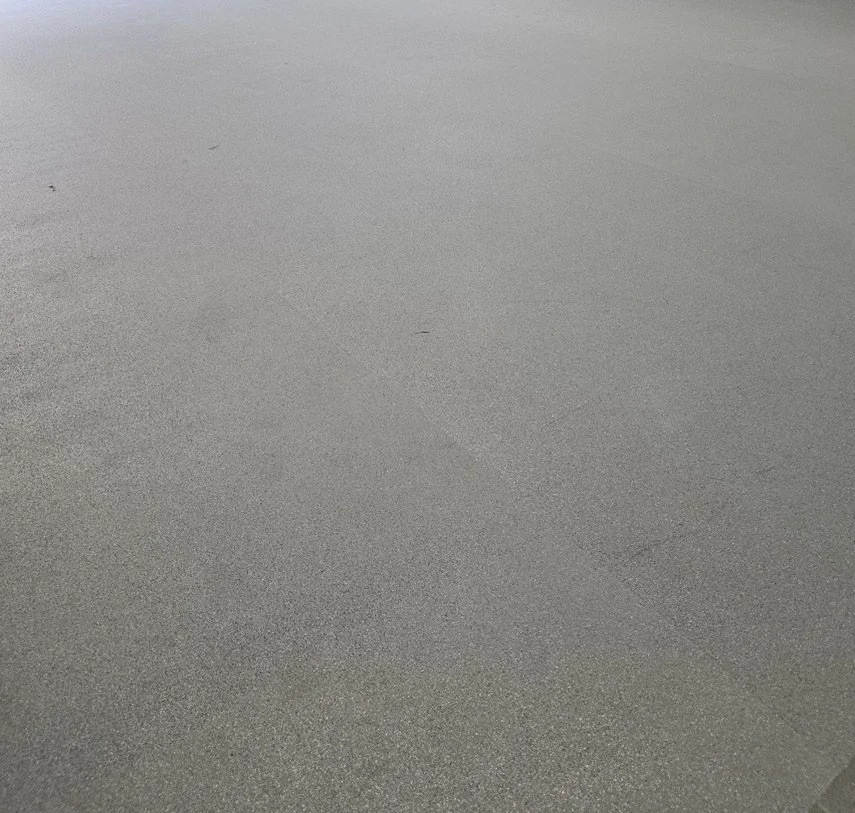 Scenic landscape with turquoise lake, rolling green hills, and majestic mountains under cloudy sky