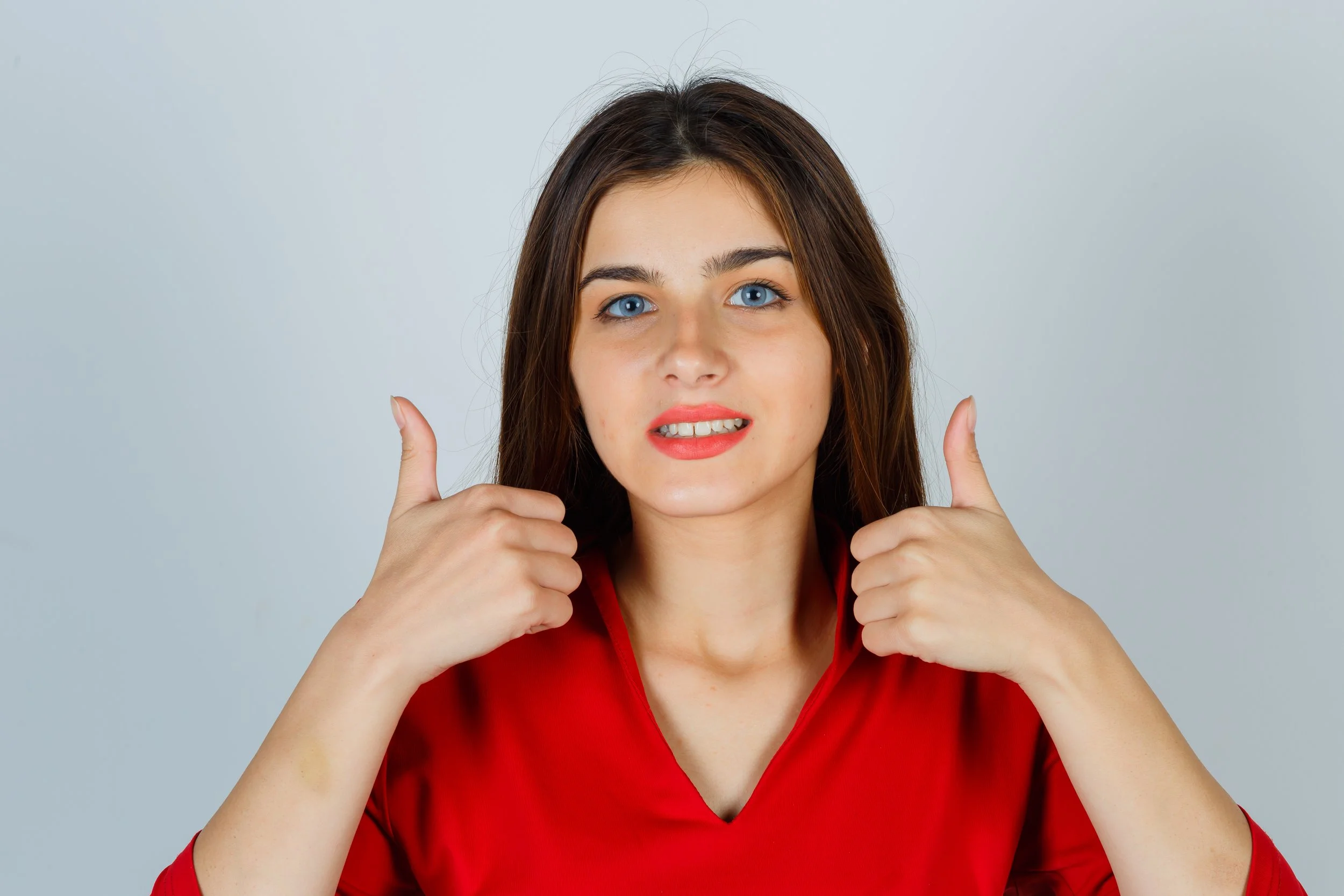 young-lady-red-blouse-showing-thumbs-up-looking-glad.jpg