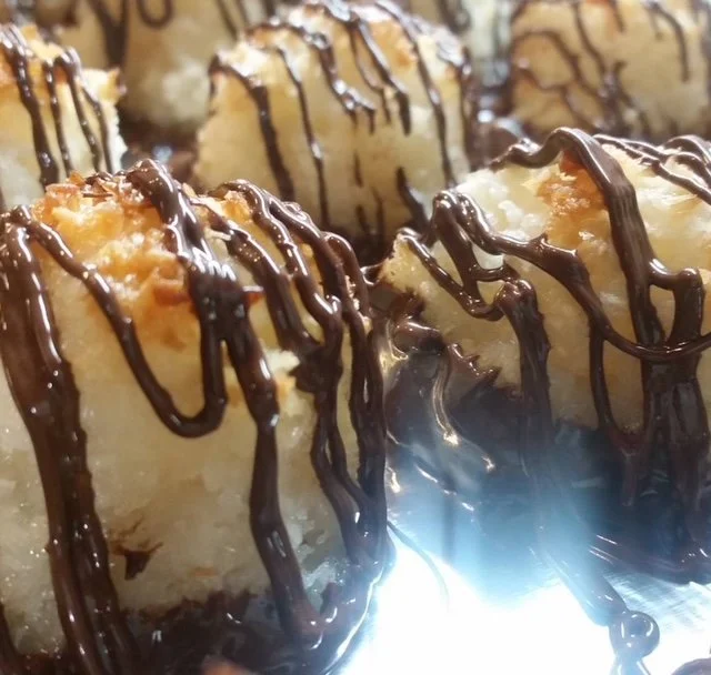 Close-up of coconut macaroons drizzled with chocolate.