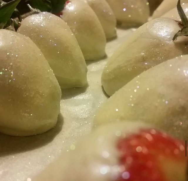 Close-up of several peeled apples arranged on a surface, with some water droplets and a hint of a red fruit at the bottom right corner.