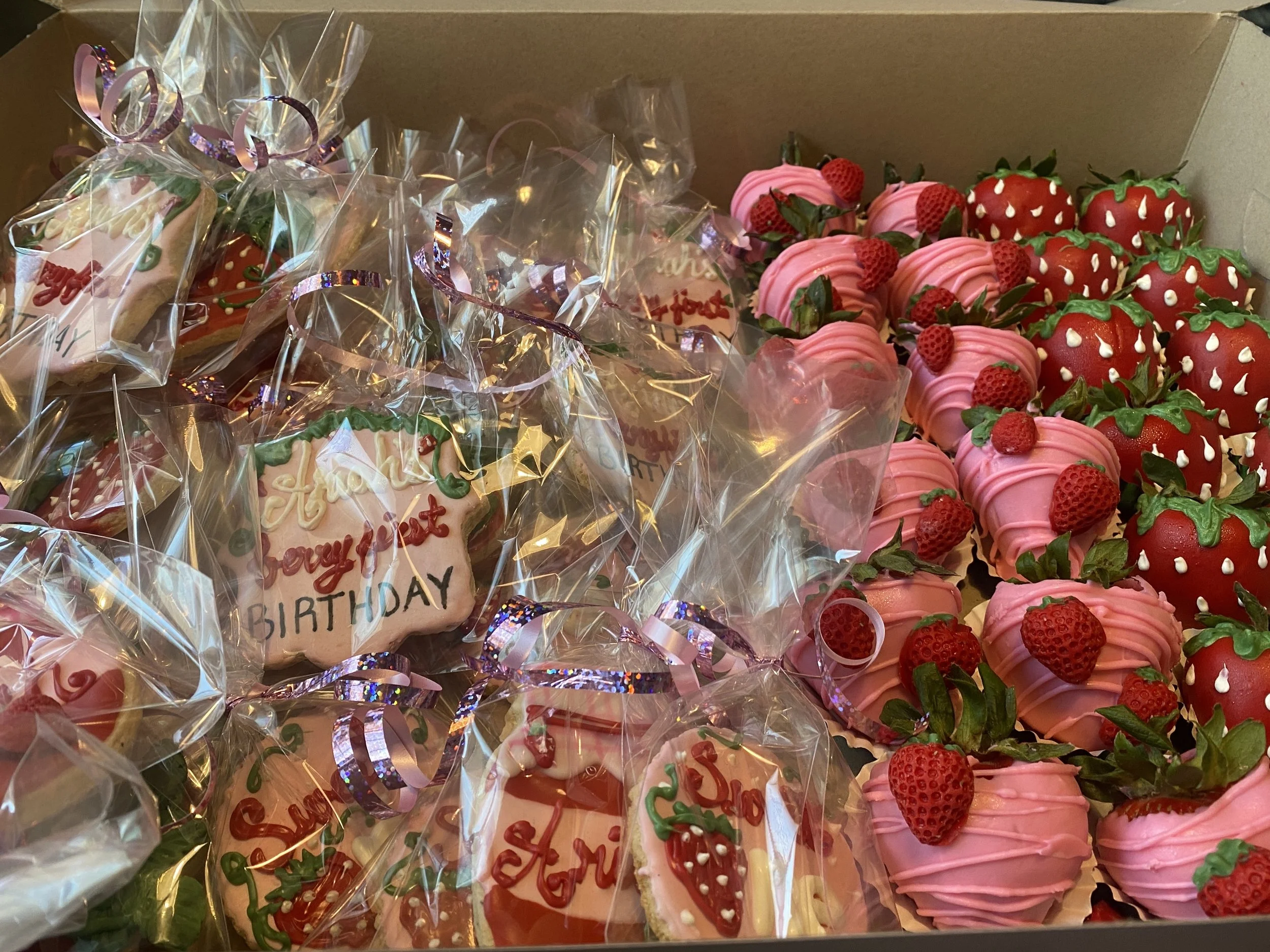 Party treat box with pink chocolate covered strawberries and custom faced sugar cookies