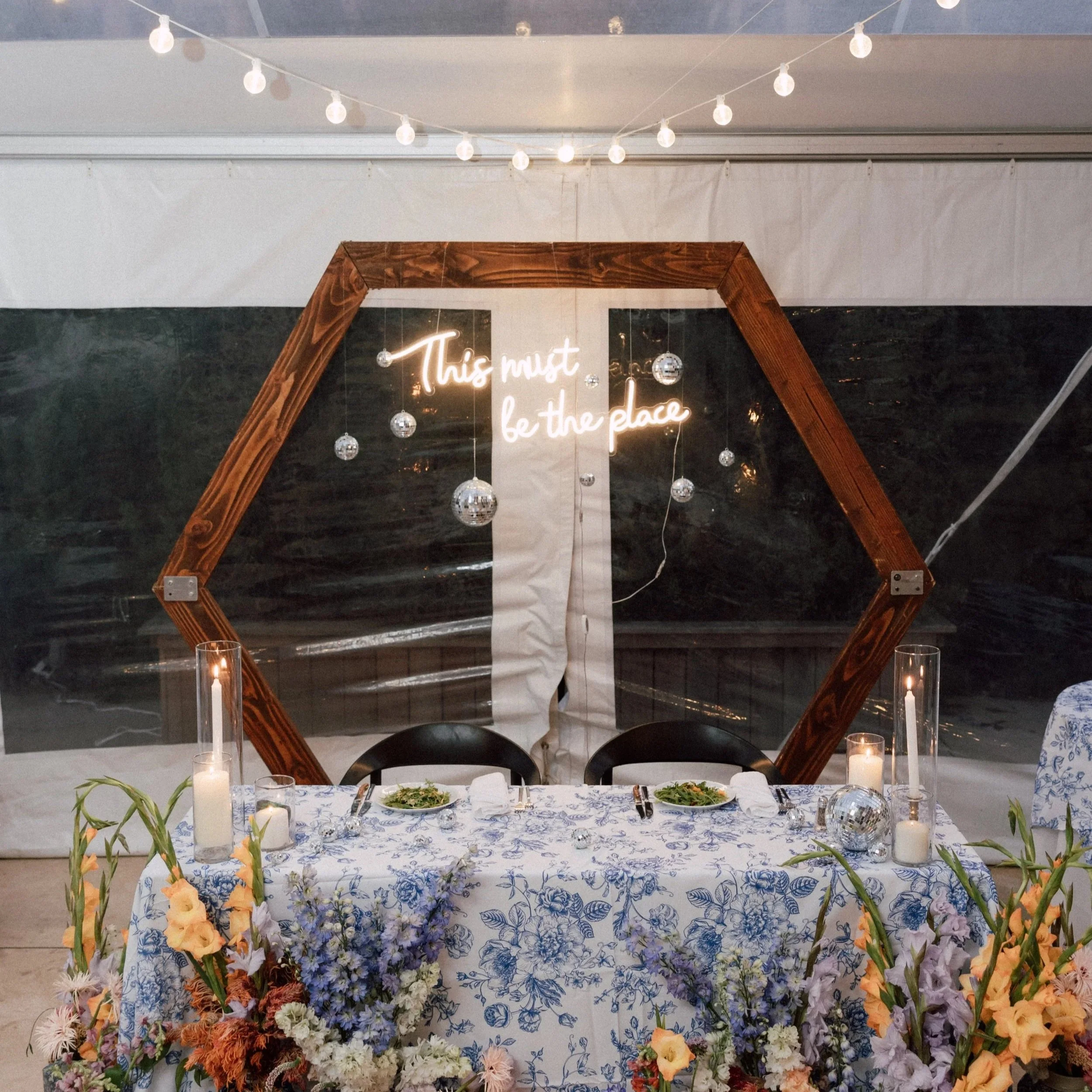 sweetheart+table+blue+floral+tablecloth+hexagon+arch+this+must+be+the+place+neon+sign.jpg