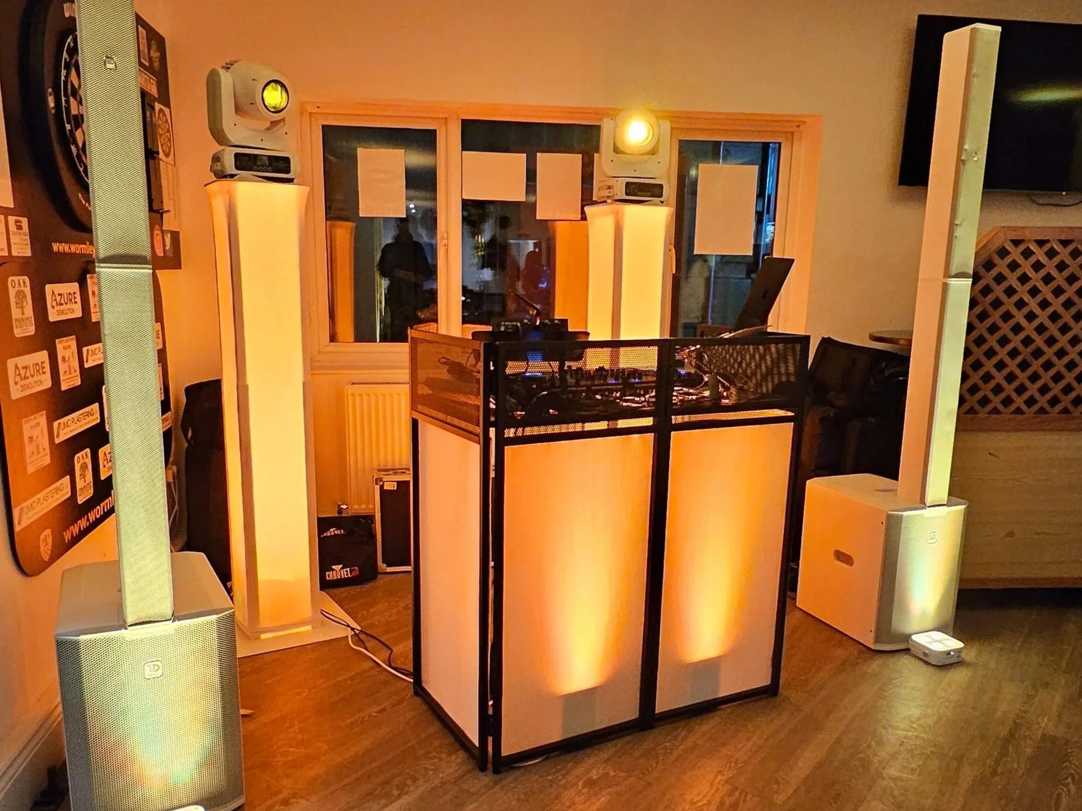 DJ booth with lighting and speakers set up in a room.