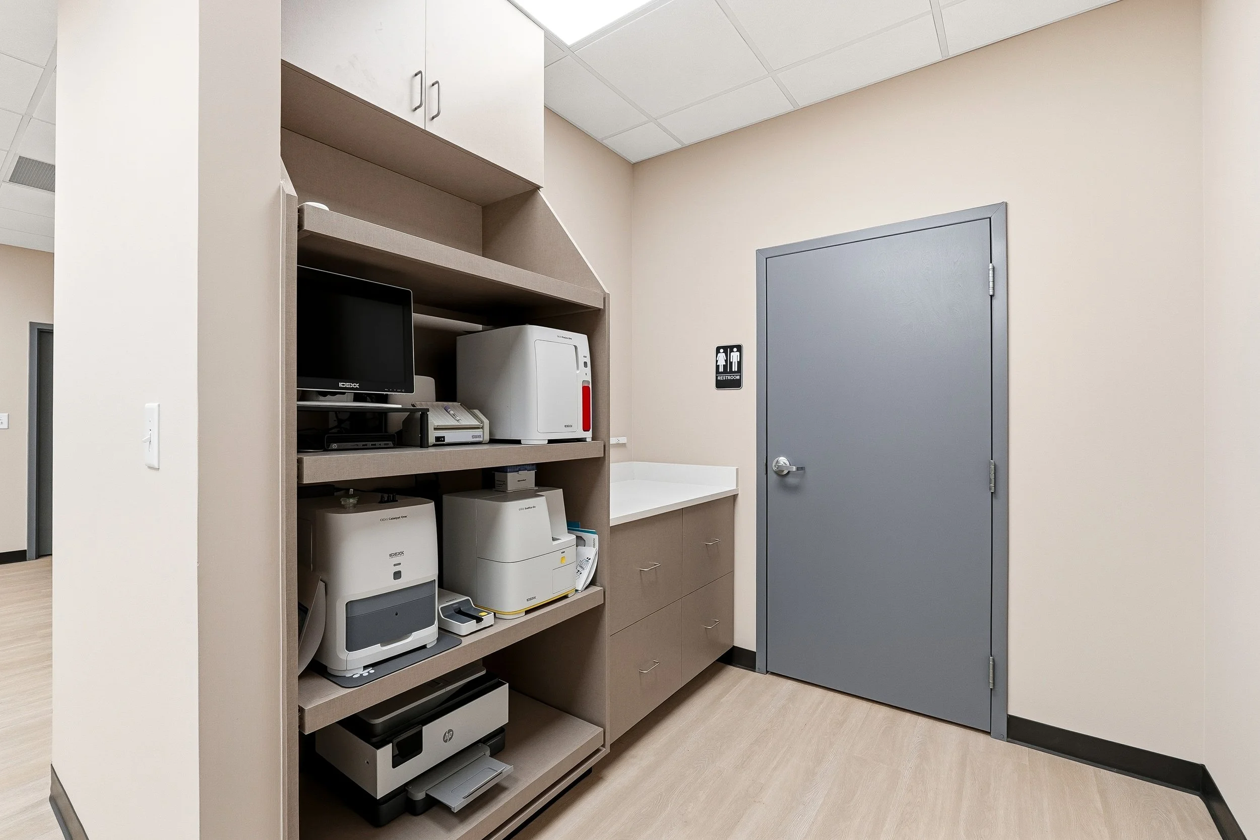 Laboratory room with built in cabinets holding diagnostic equipment for in-house urinalyses, blood work and other important diagnostics. 