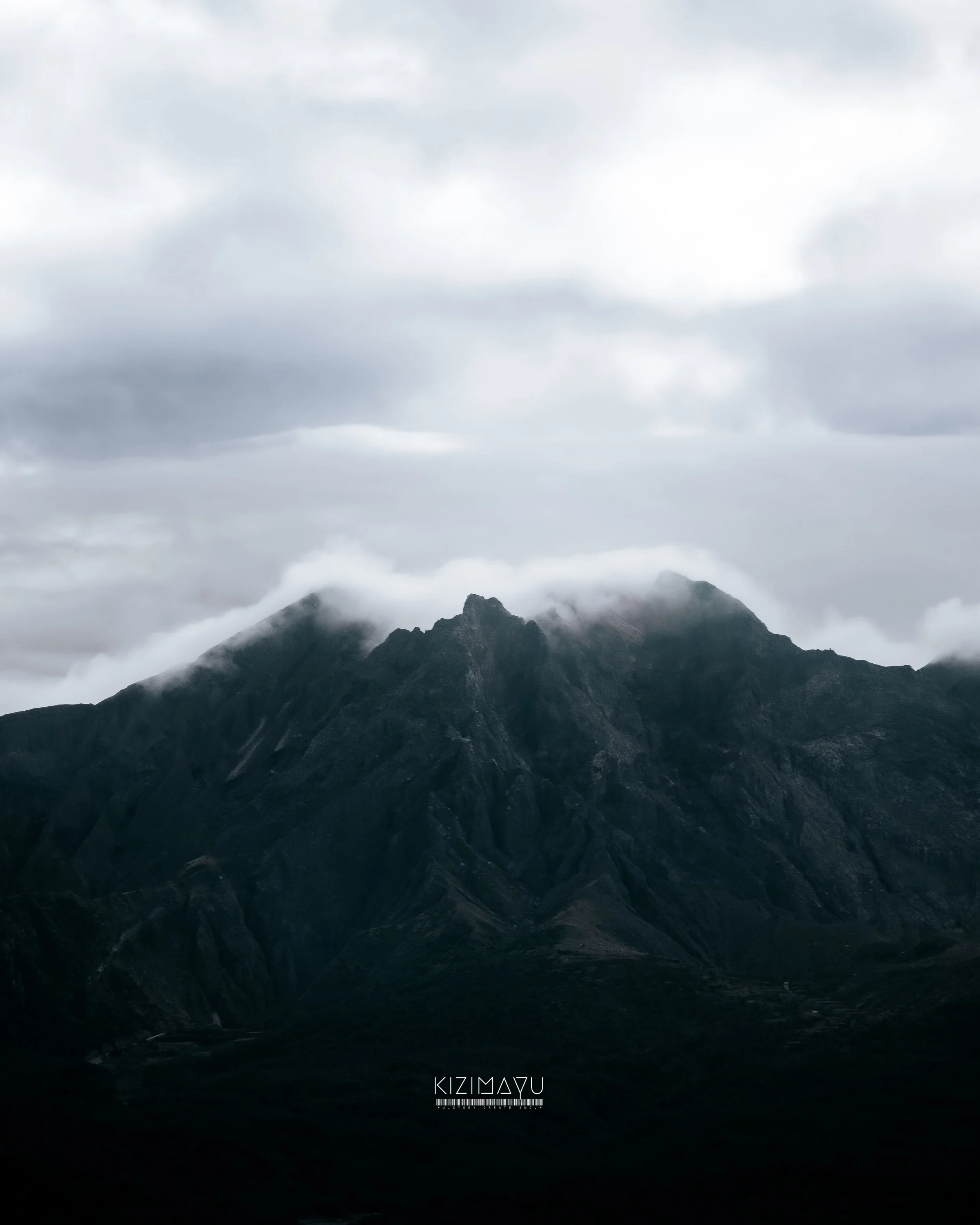 曇り空の下、山の稜線が見える黒い山々