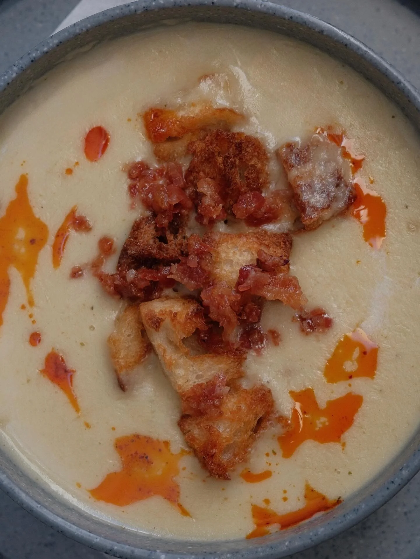 Sopita de temporada que reconforta 🥣

Cebolla, ajo, tocino, crutones de masa madre tostados al horno y un toque de aceite de chiles 🧅✨

#CretoDeli