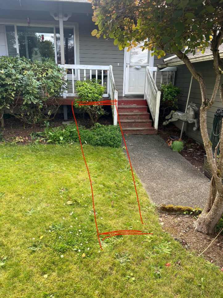 Lawn with a red line indicating a path from the bottom of the yard to the porch stairs, with plants and bushes around the yard, a tree on the right, and a house with a white door and stairs in the background.